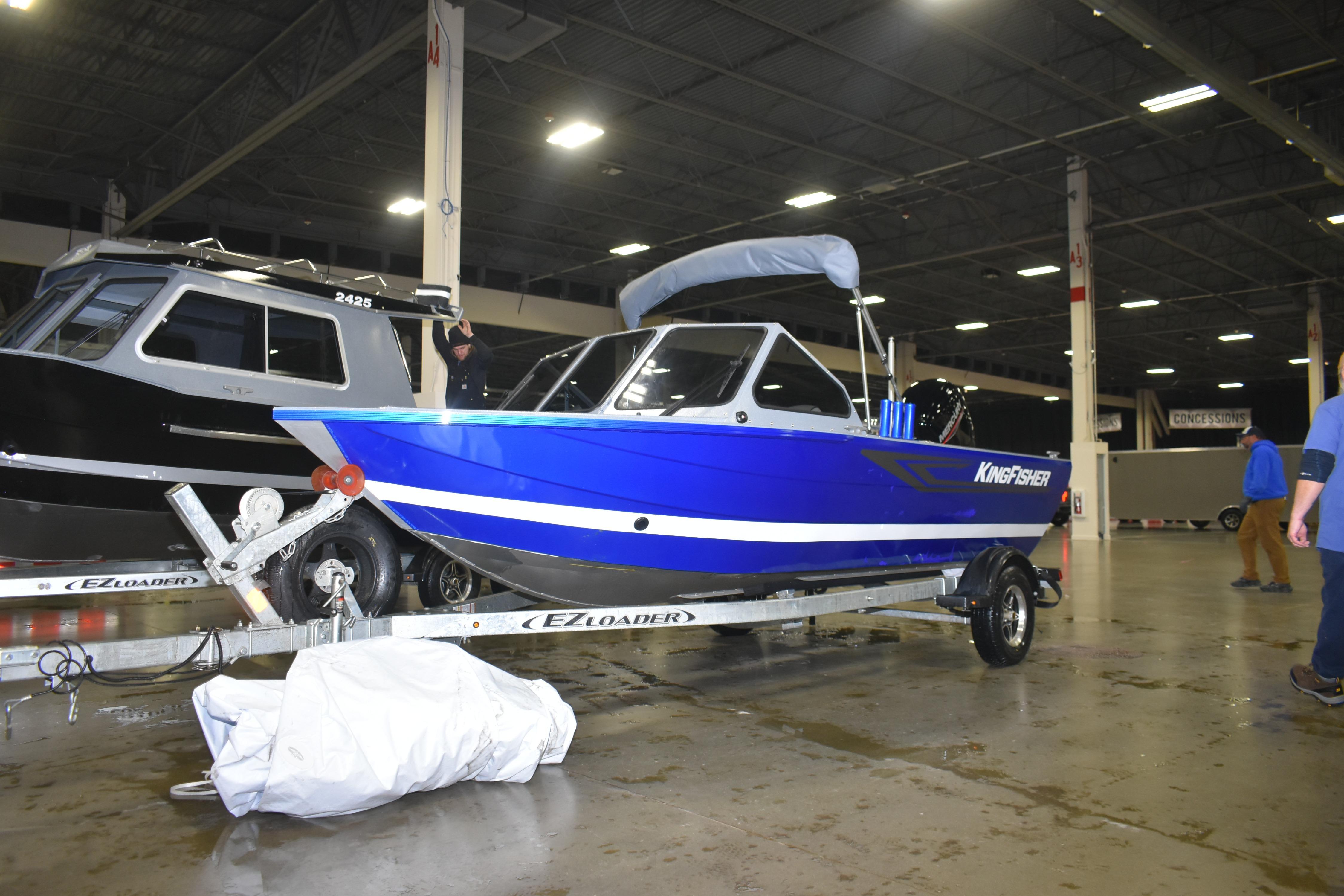 2026 KingFisher 1825 Falcon boat on trailer in indoor showroom.