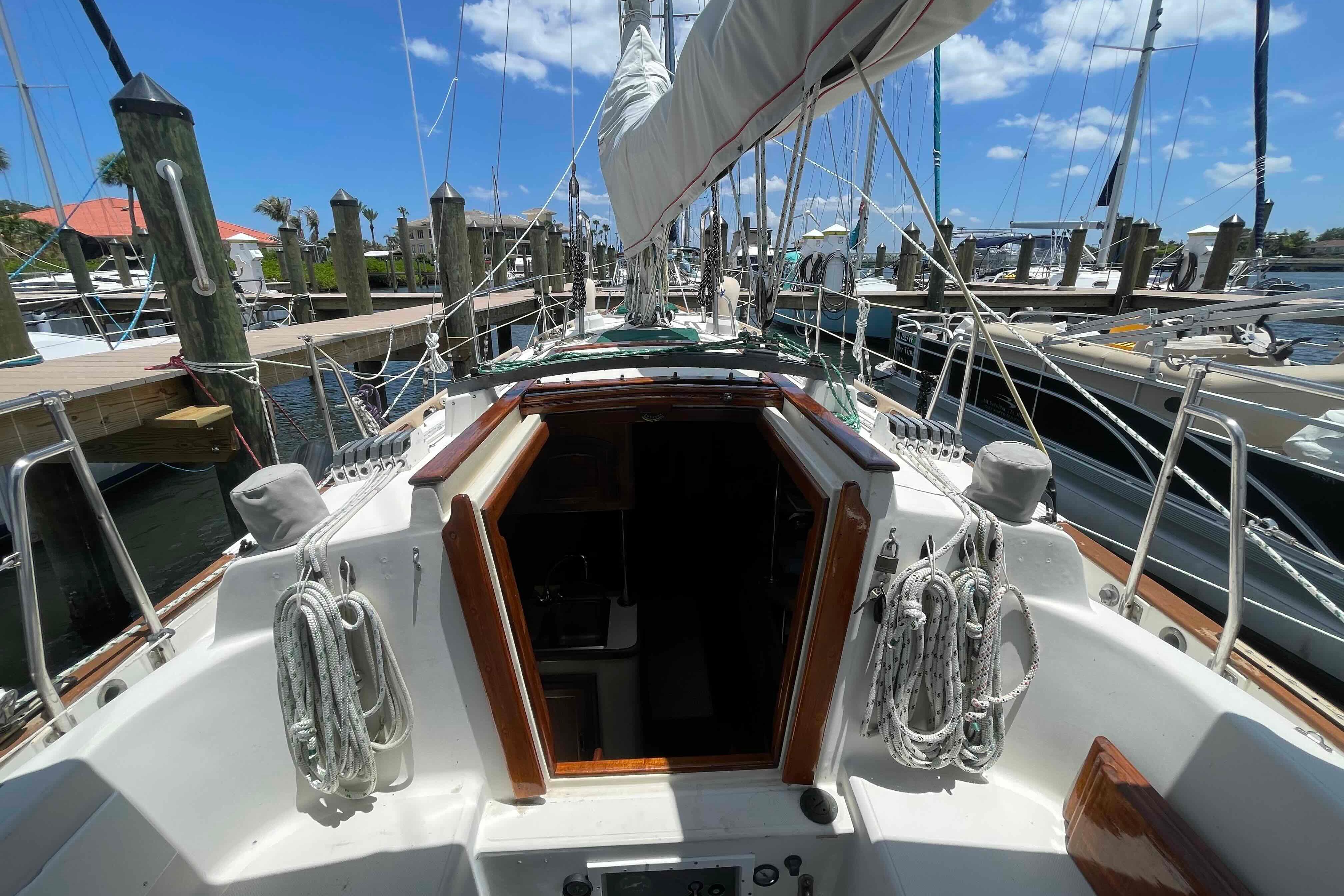 1987 Pacific Seacraft 34 sailboat docked at marina under clear blue sky.