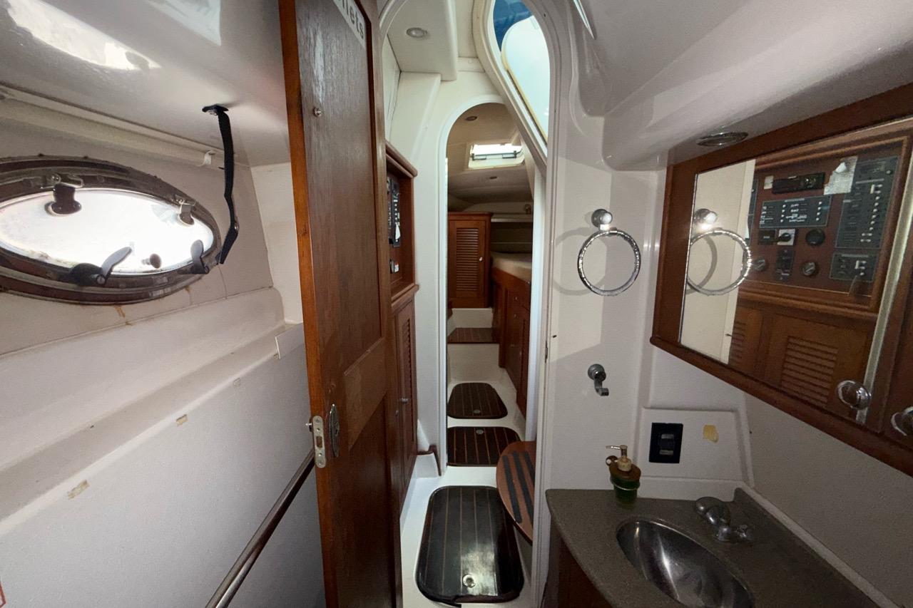 Interior of 2005 Glacier Bay 3480 Ocean Runner, featuring a compact bathroom and wooden accents.