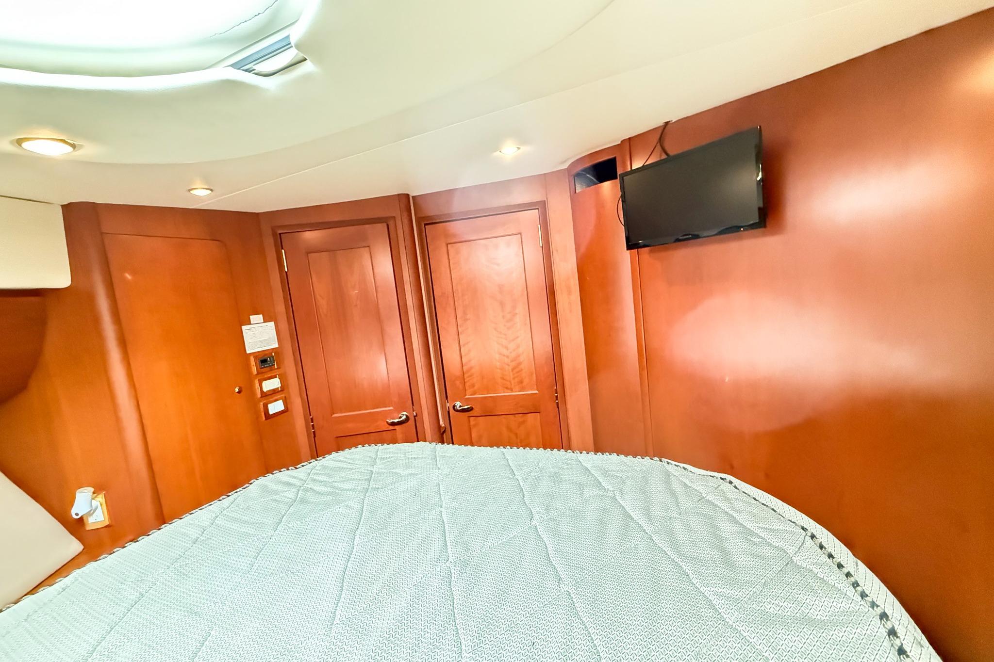 Interior of 2004 Silverton 48 Convertible yacht with wood paneling and mounted TV.