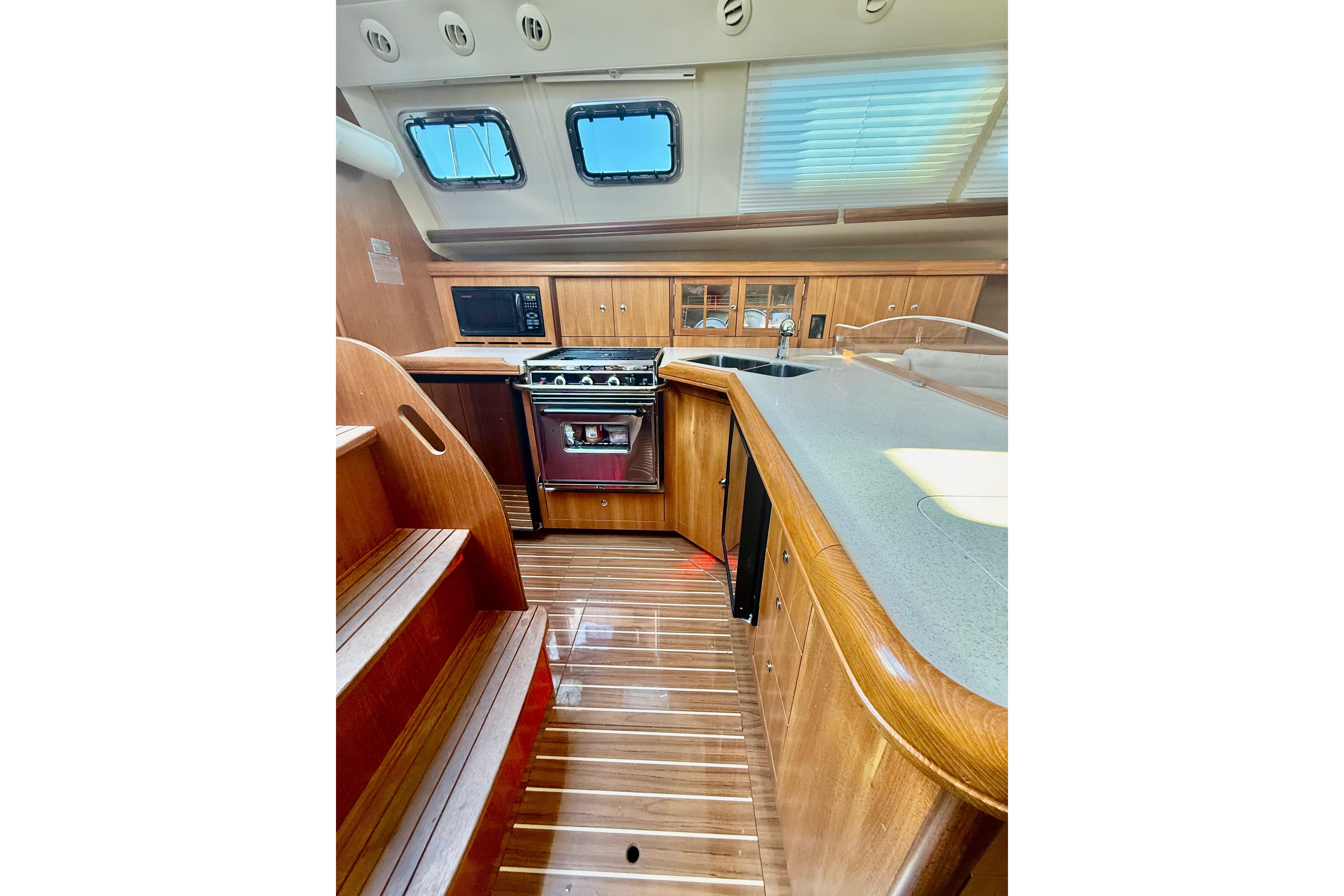 2007 Hunter 41 Deck Salon interior with wooden cabinetry and modern kitchen appliances.