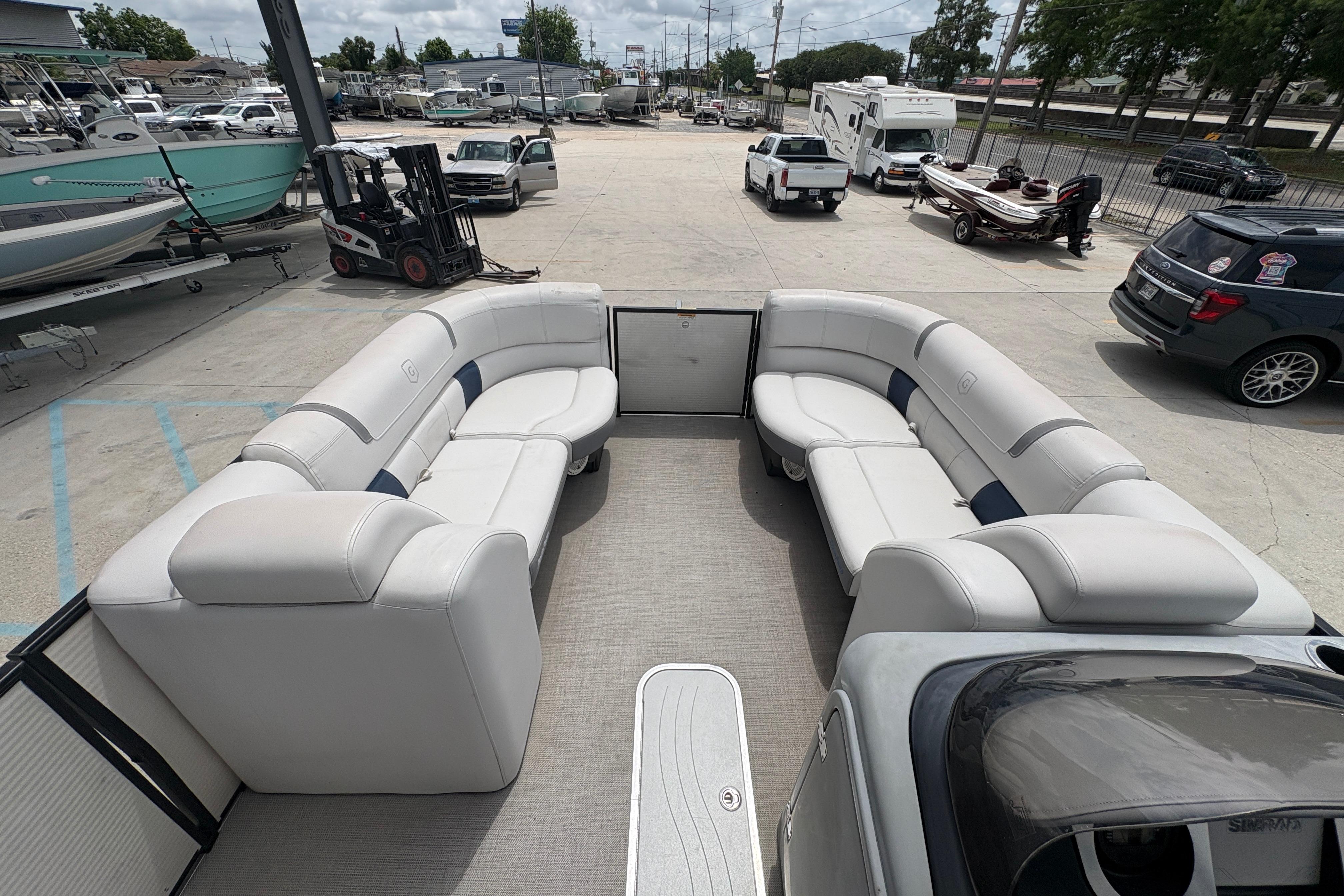 2019 Godfrey Aqua Patio pontoon boat with spacious seating, parked in a marina lot.