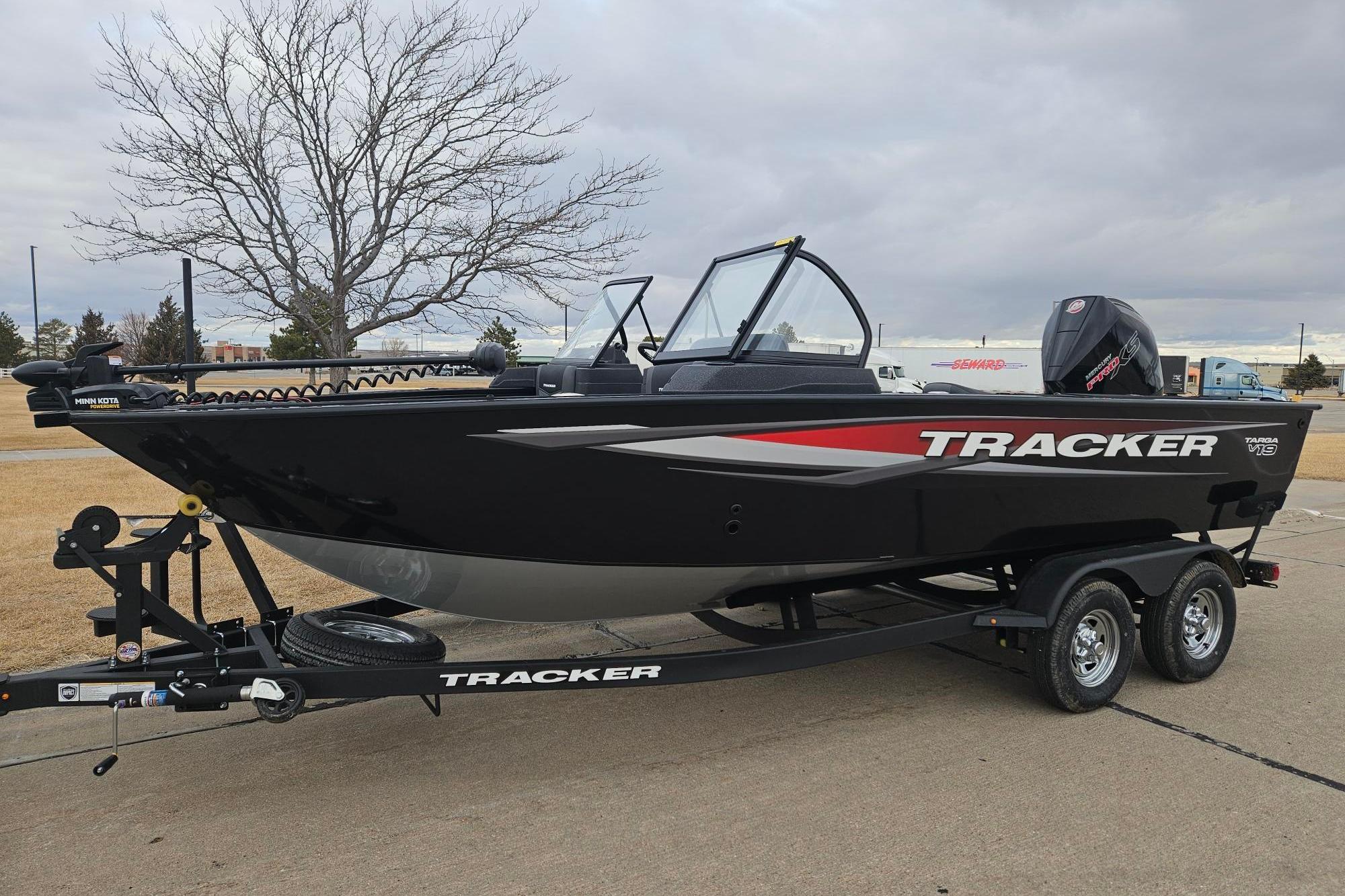 2026 Tracker Targa V-19 WT boat on trailer, black with red accents, parked outdoors.