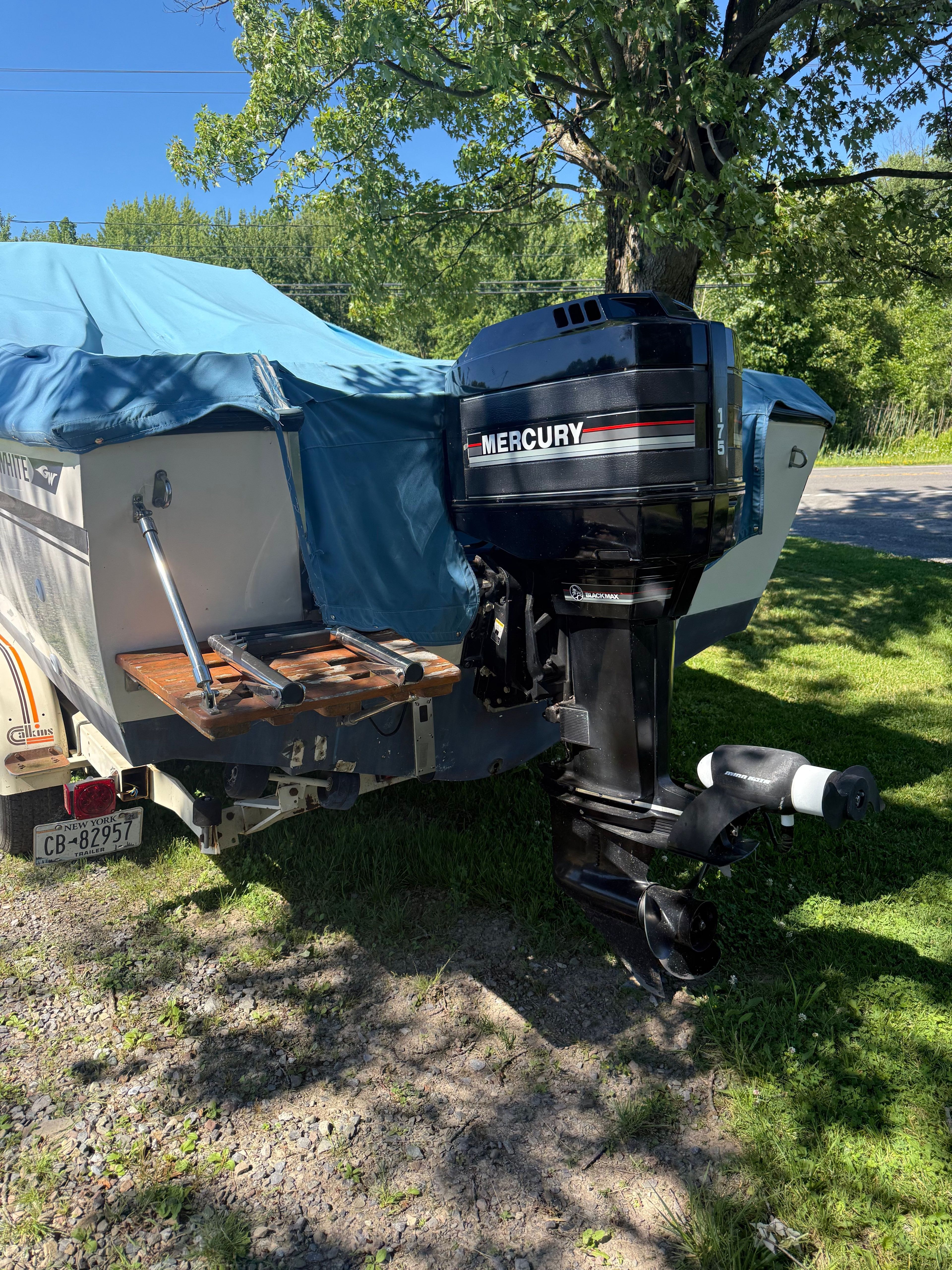 A 1989 Grady-White Tournament Fisherman with a Mercury outboard motor, covered and on a trailer.
