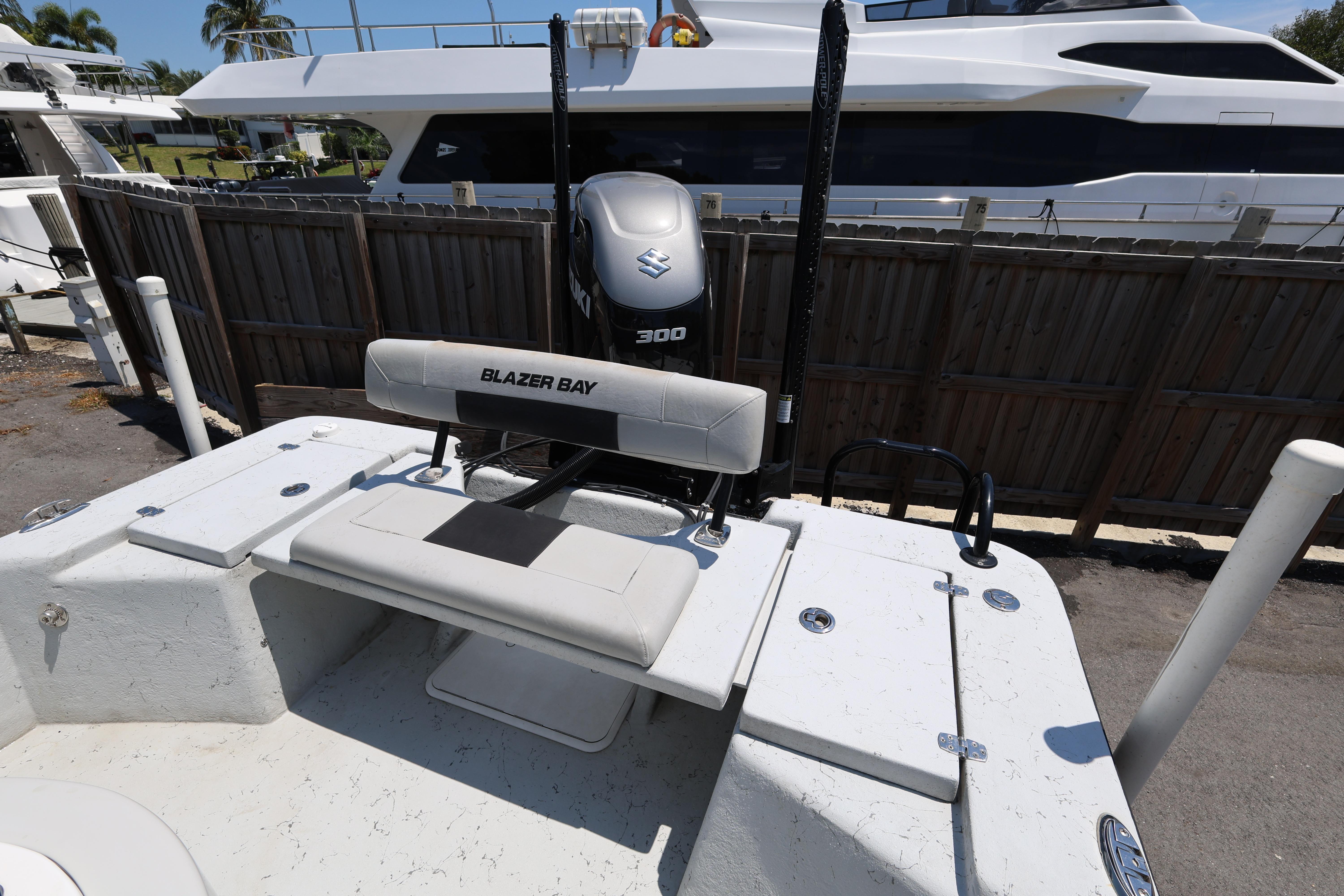 2021 Blazer Bay 2400 boat with Suzuki 300 engine, docked near a yacht.