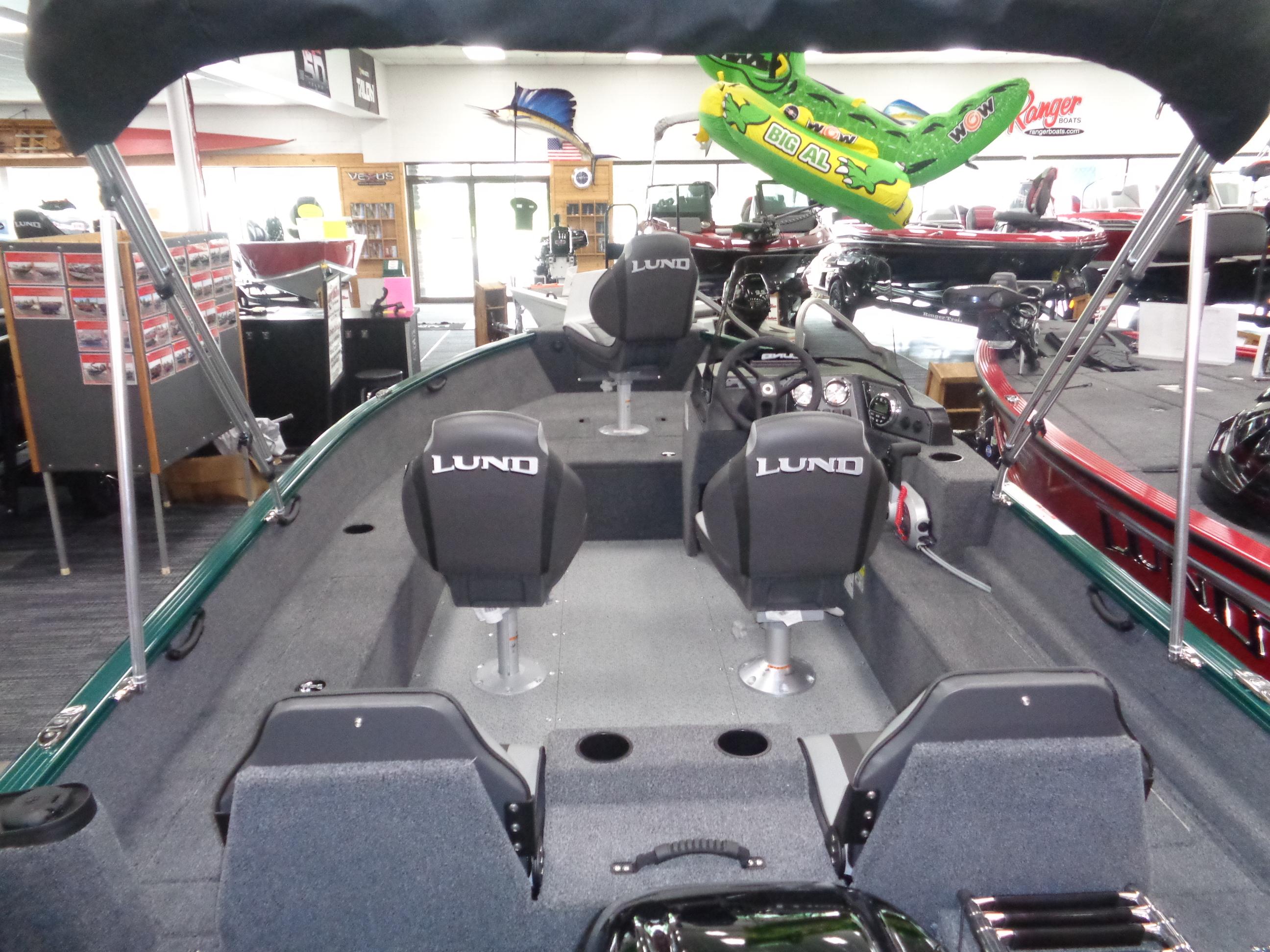 2025 Lund 1650 Rebel XL SS boat interior with seating and steering console in showroom.