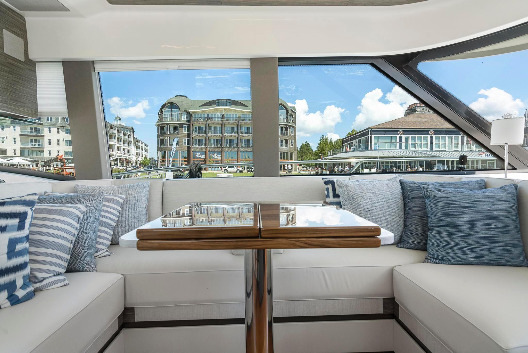 Interior of 2022 Tiara Yachts C49 Coupe with elegant seating and scenic marina view.