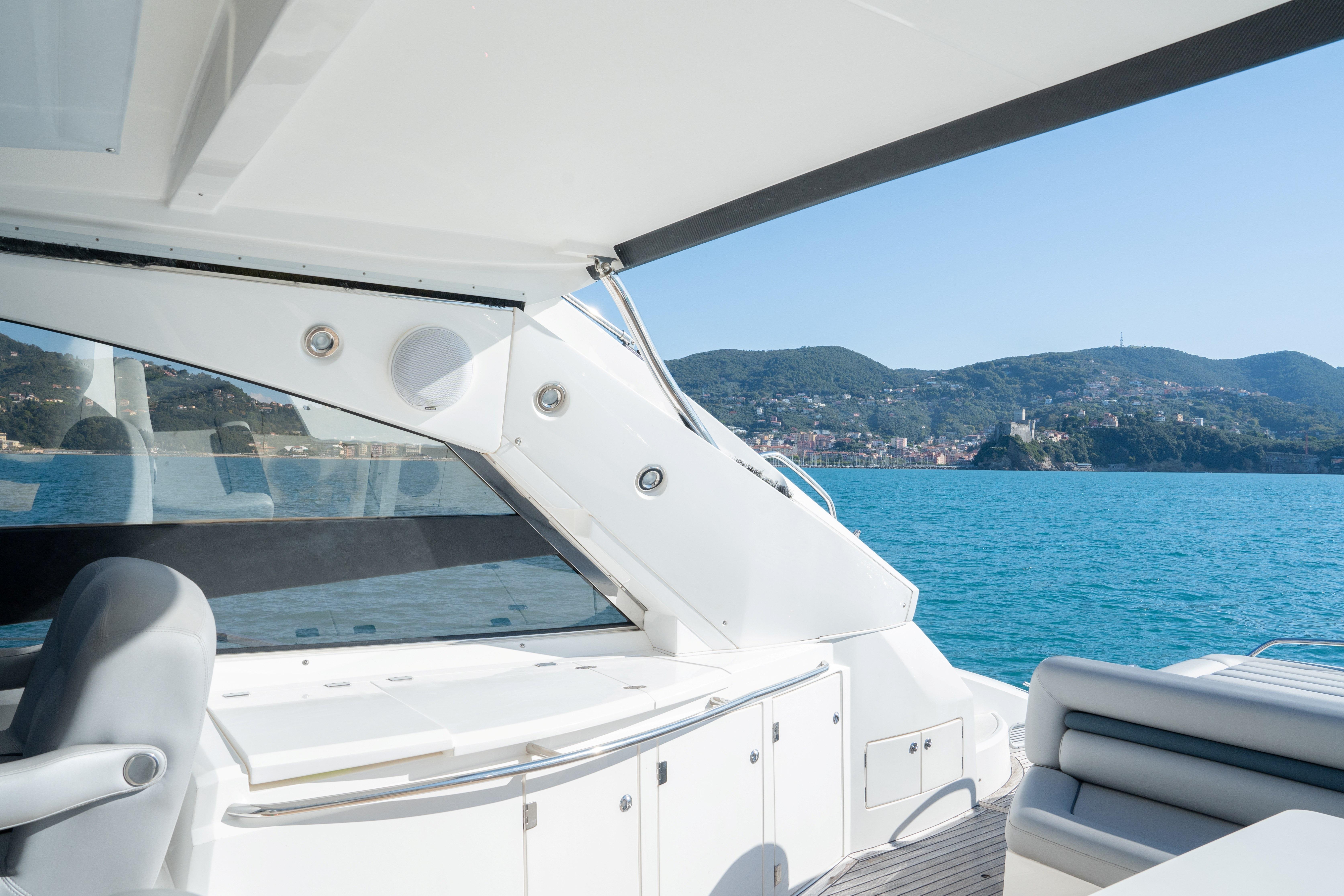 Luxurious 2005 Sunseeker Portofino 53 yacht interior with scenic ocean and mountain view.