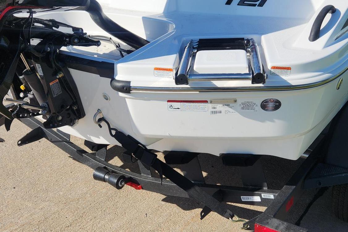 2026 Tahoe T21 boat rear view with motor and trailer, showcasing sleek design.