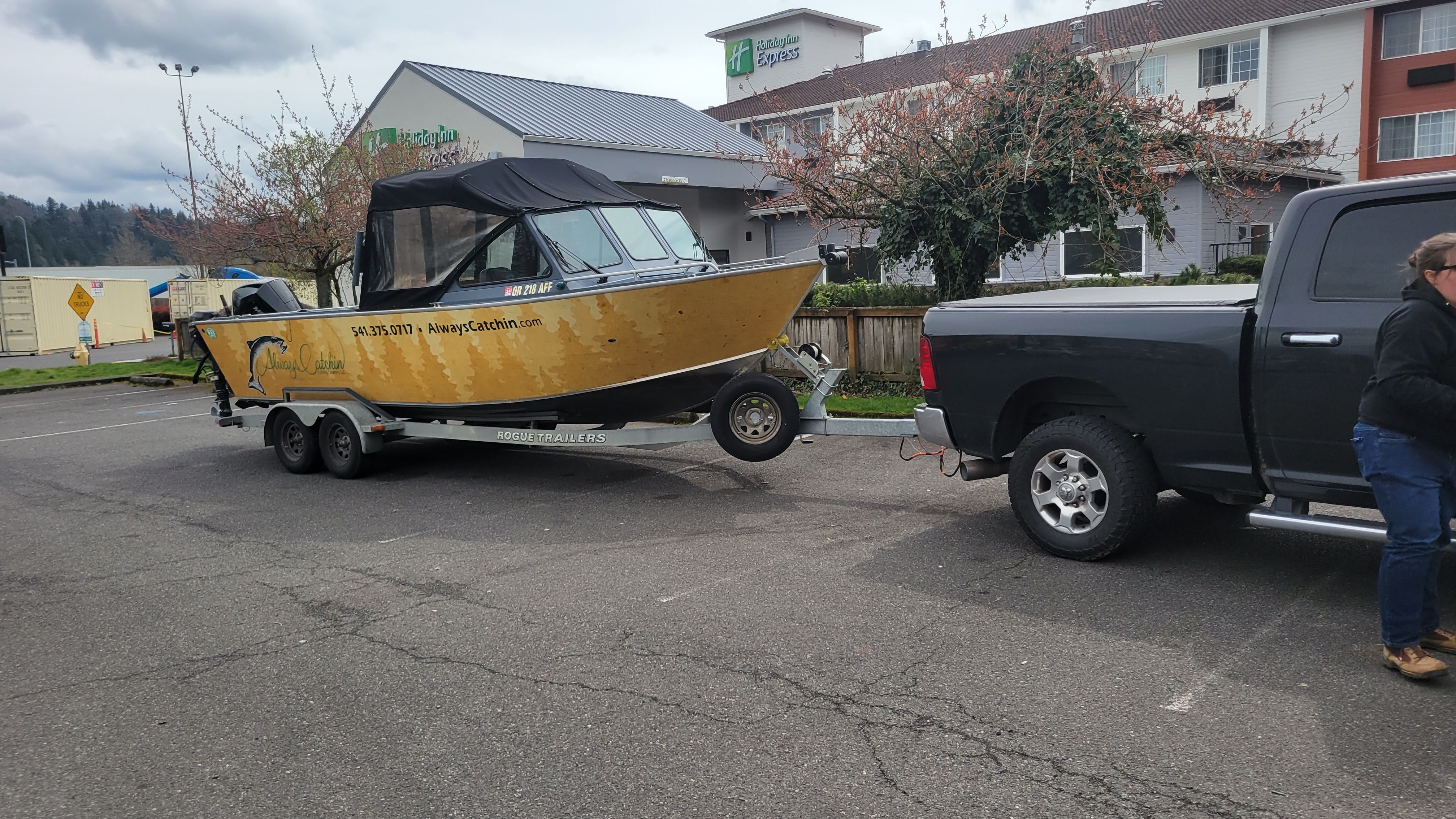 A 2015 Alumaweld Formula Vee Outboard 24 boat on a trailer, towed by a pickup truck.