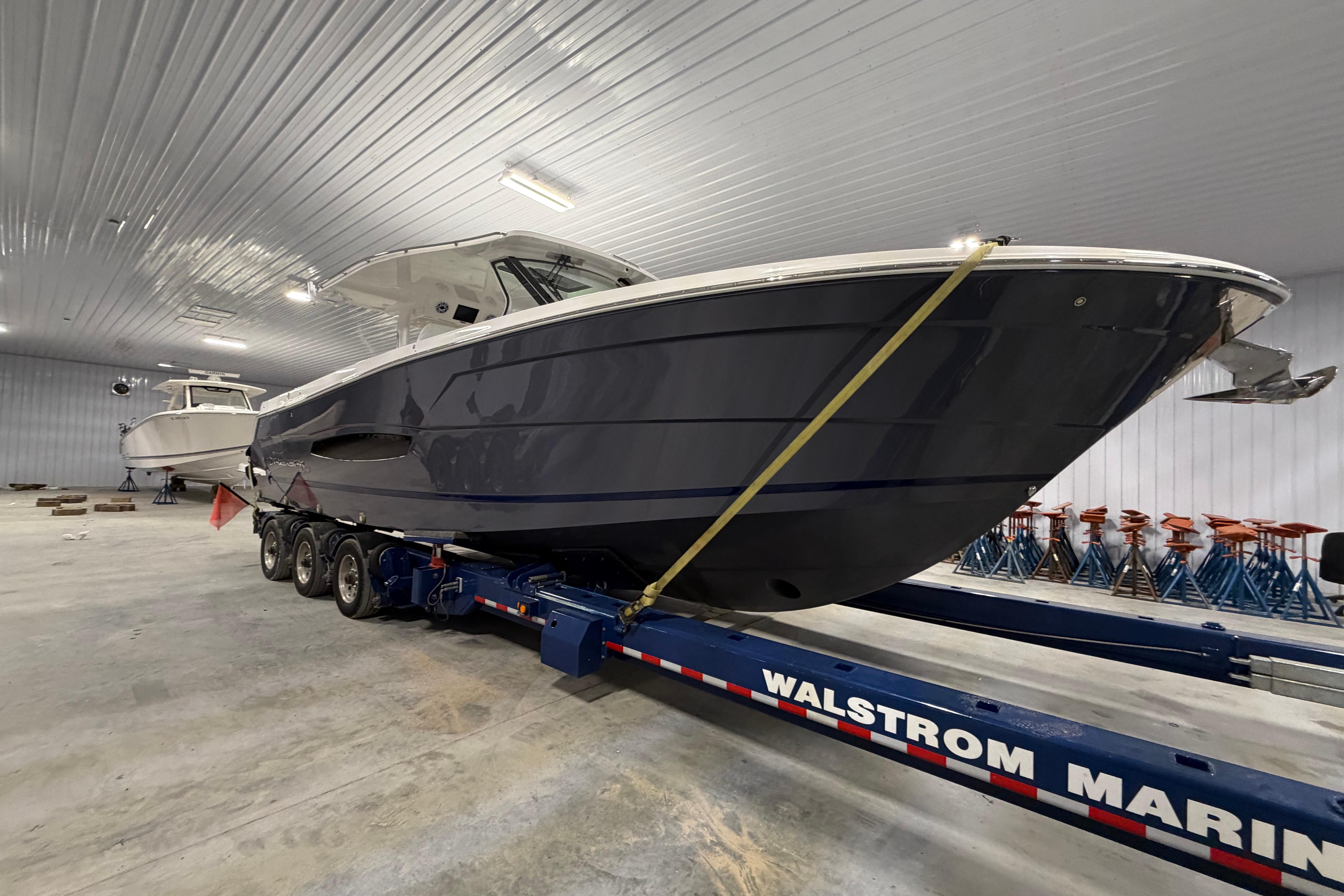 2027 Regal 38 Surf boat on trailer in indoor storage facility.