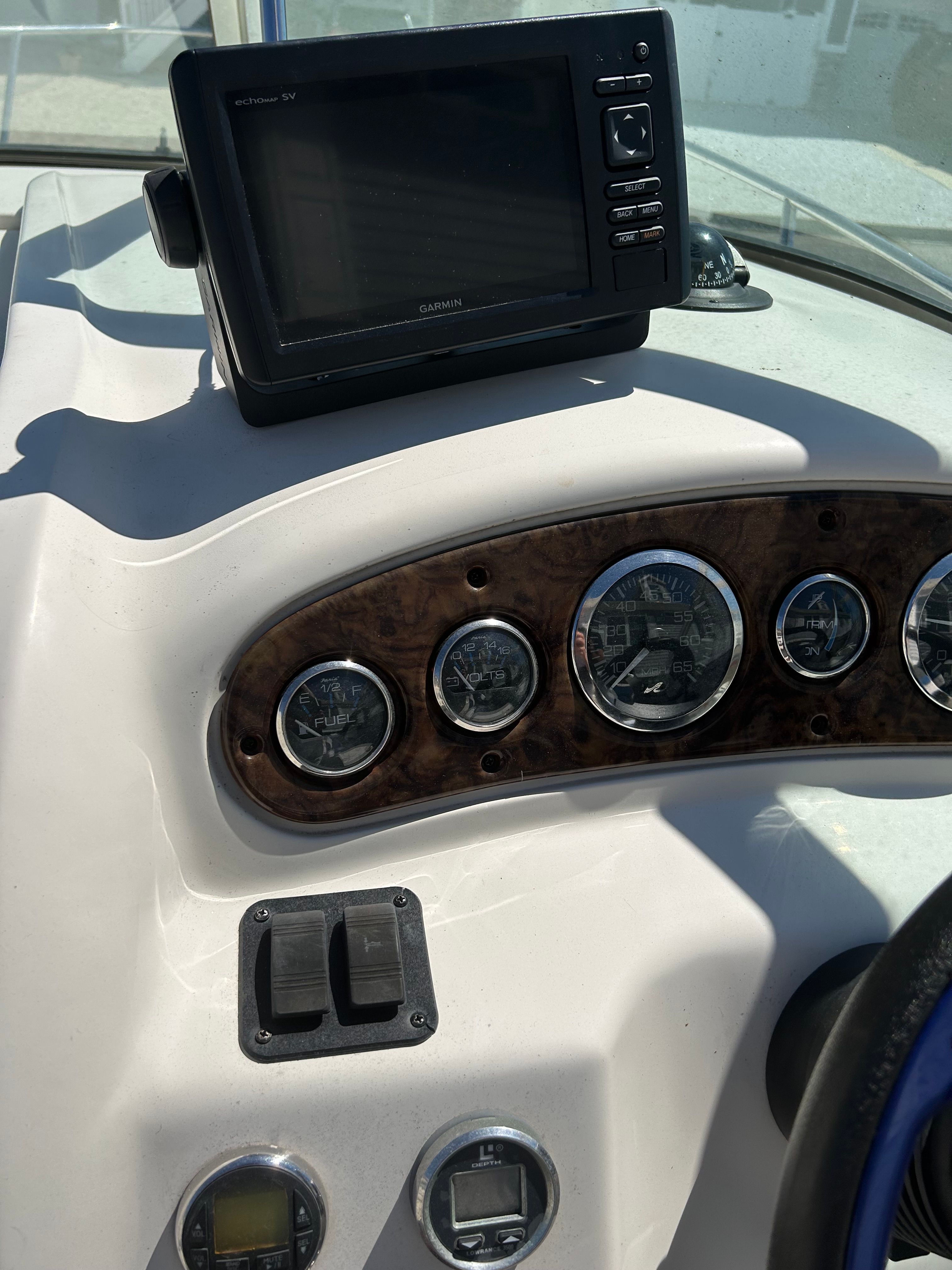 The image shows the dashboard of a Sea Ray 225 Weekender with a Garmin navigation device.