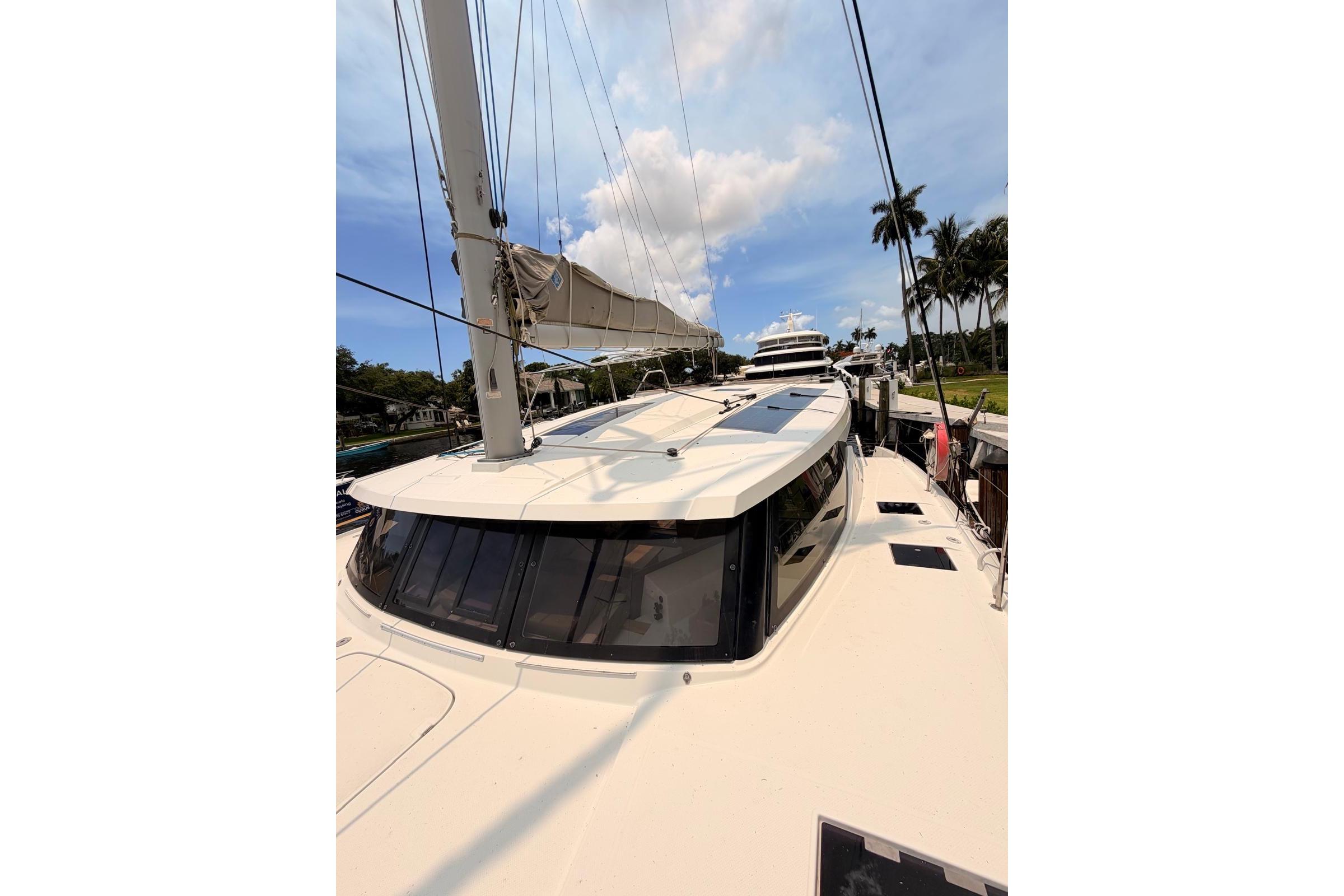 2018 Fountaine Pajot Lucia 40 catamaran docked, with clear skies and palm trees.