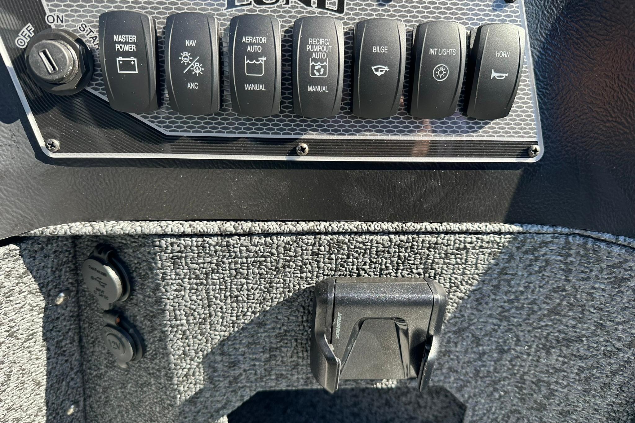 Control panel of 2026 Lund 1875 Impact XS Sport boat with various switches.