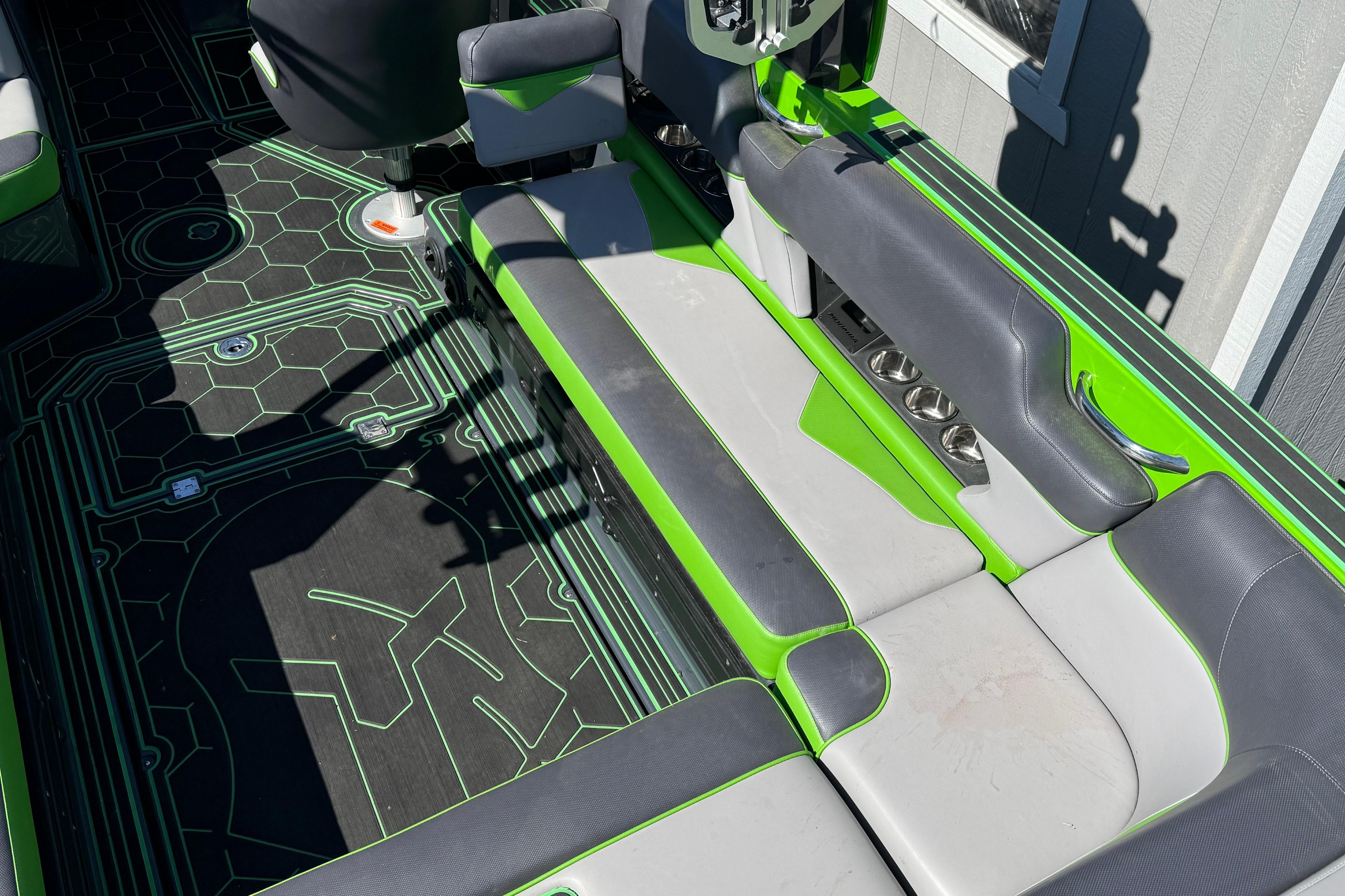 2022 Moomba Makai boat interior with green and gray seating and geometric floor design.