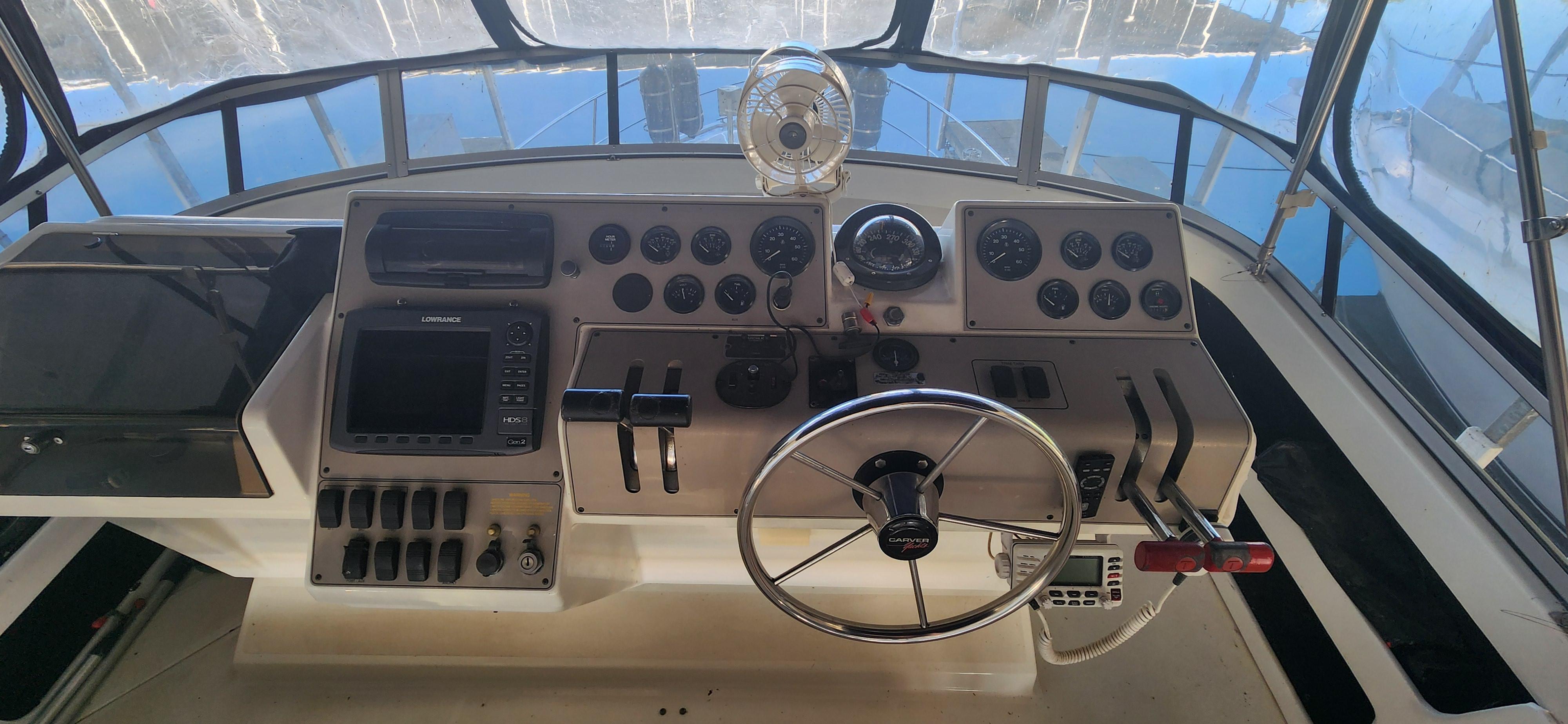 1996 Carver 400 Cockpit Motor Yacht helm with steering wheel and control panel.