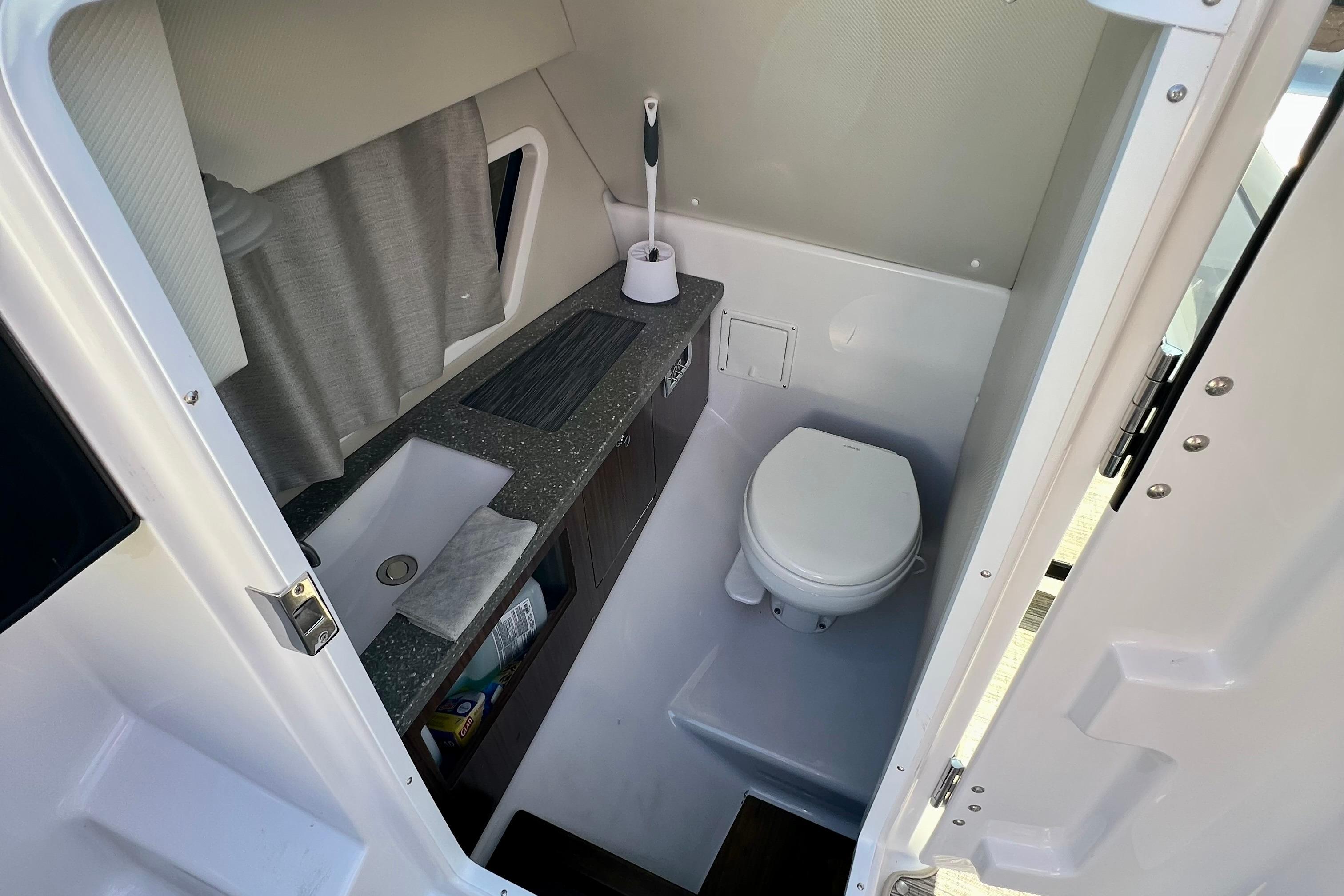 2019 Four Winns Horizon H290 boat bathroom with sink, toilet, and storage.