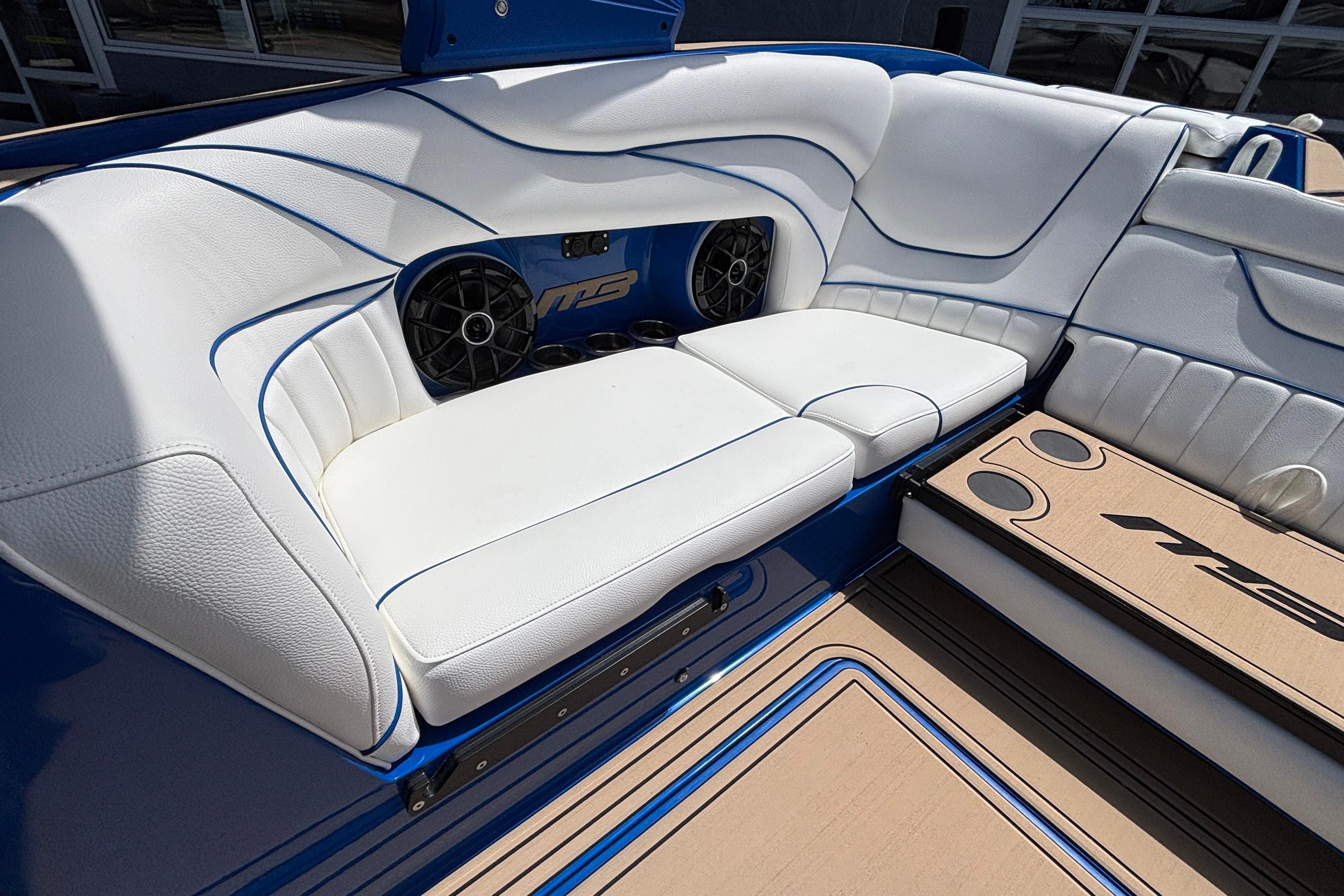 Luxurious seating in 2026 MB B52 23 Alpha boat with white upholstery and speakers.
