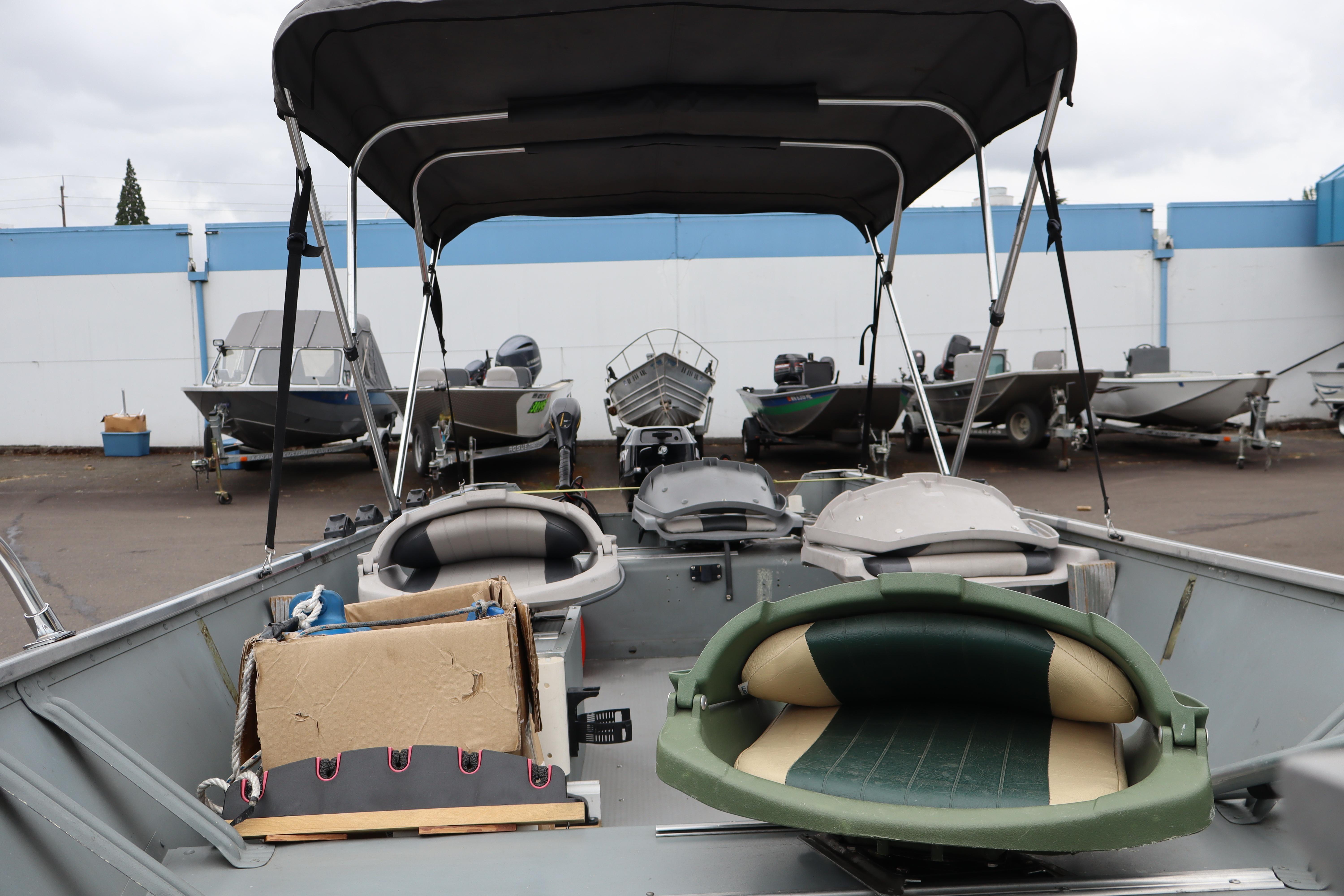 2006 Smoker Craft Alaskan 15 boat with canopy, parked among other boats.