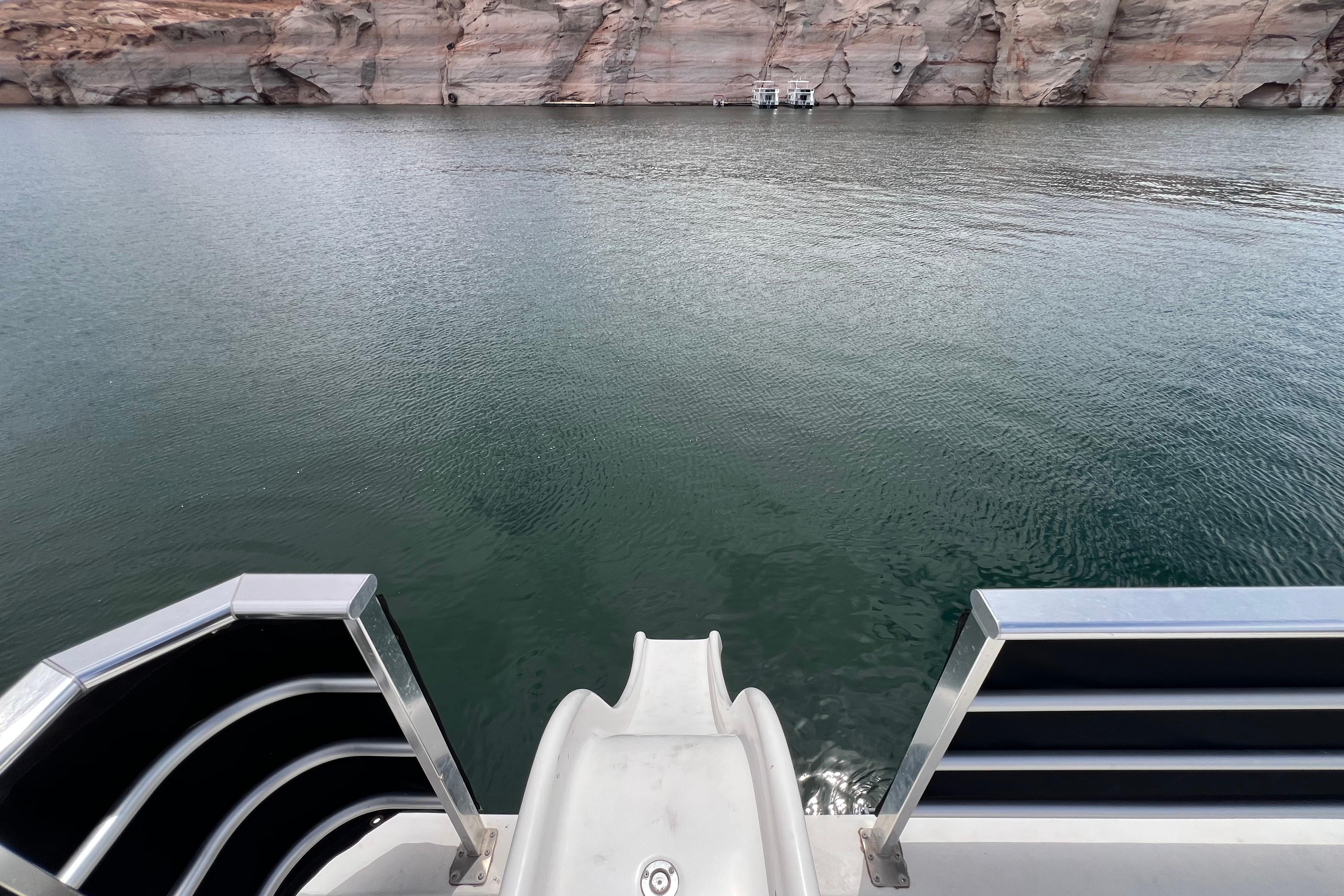 View from 2013 Destination Yacht Lotta Yachta slide into serene lake with rocky cliffs.