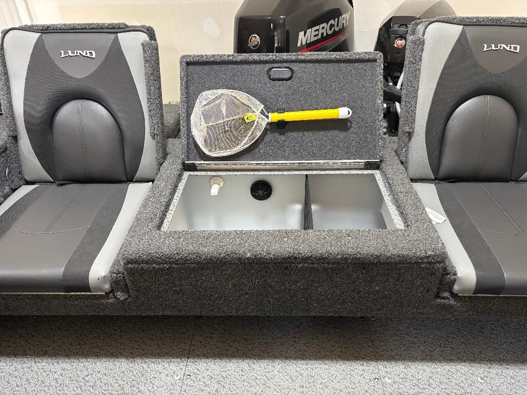 Interior of a Lund boat with gray seats and a storage compartment.