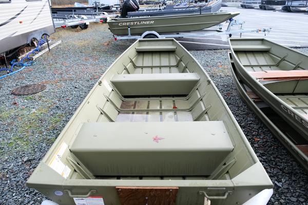 2024 Crestliner 1436L CR Jon boat on gravel lot, showcasing interior seating and design.