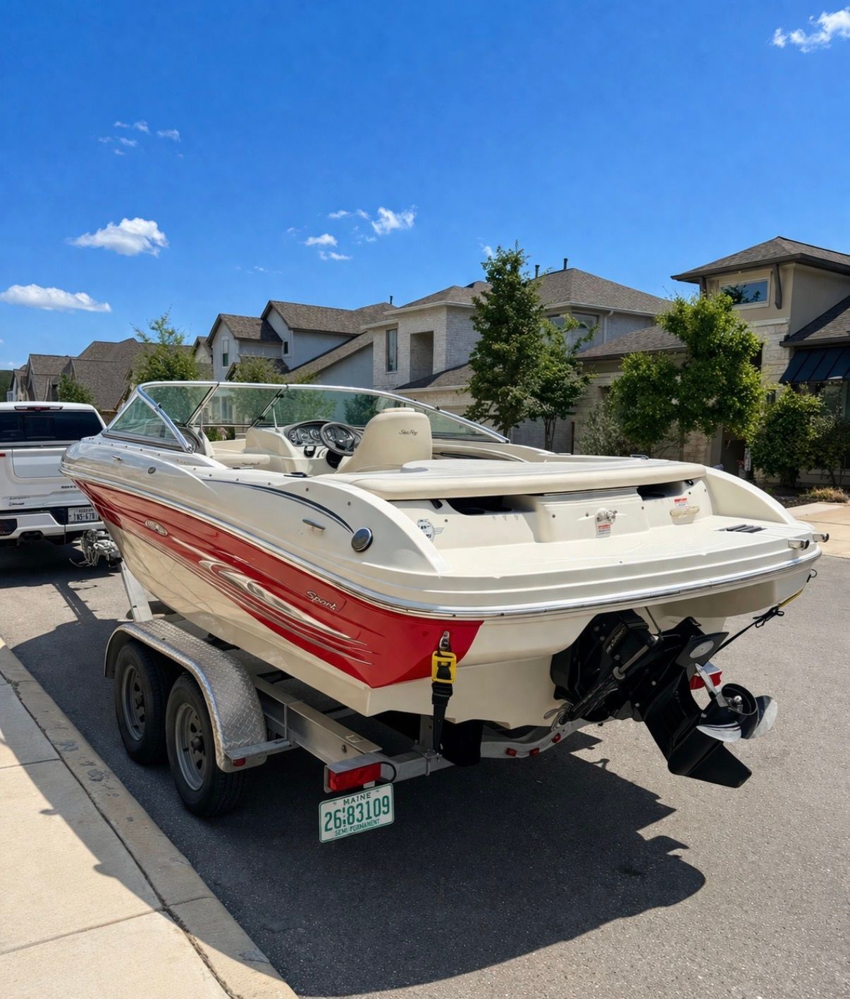 2005 Sea Ray 200 Sport boat on trailer in residential area.