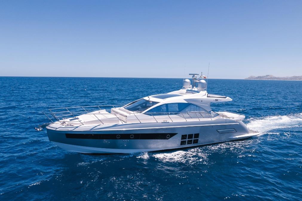 Luxury 2020 Azimut 60 yacht cruising on open blue sea under clear sky.
