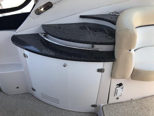 Interior of a 2008 Four Winns V338 featuring a sleek black countertop and beige seating.