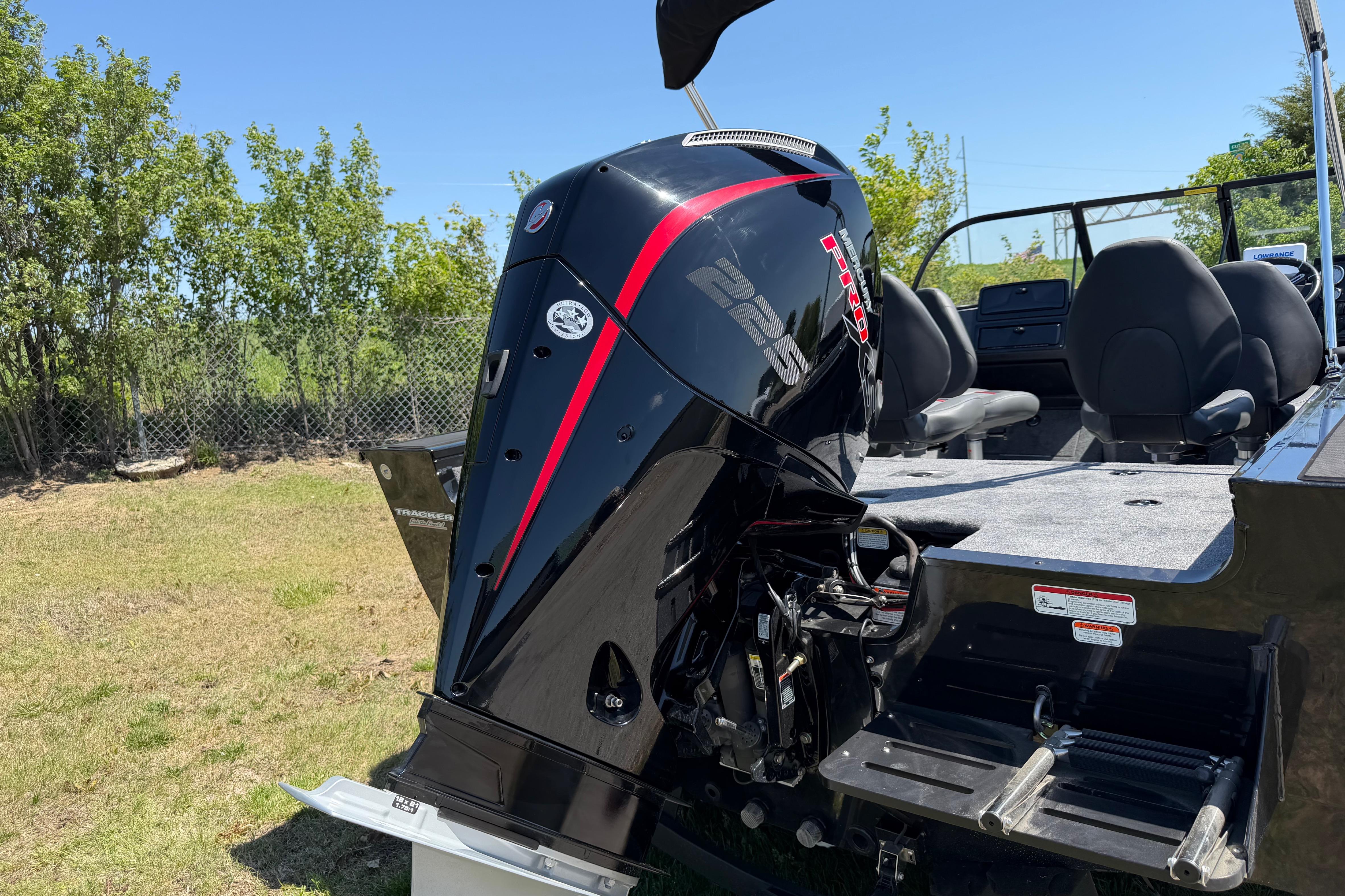 2026 Tracker Targa V-19 WT boat with powerful outboard motor, parked on grass.