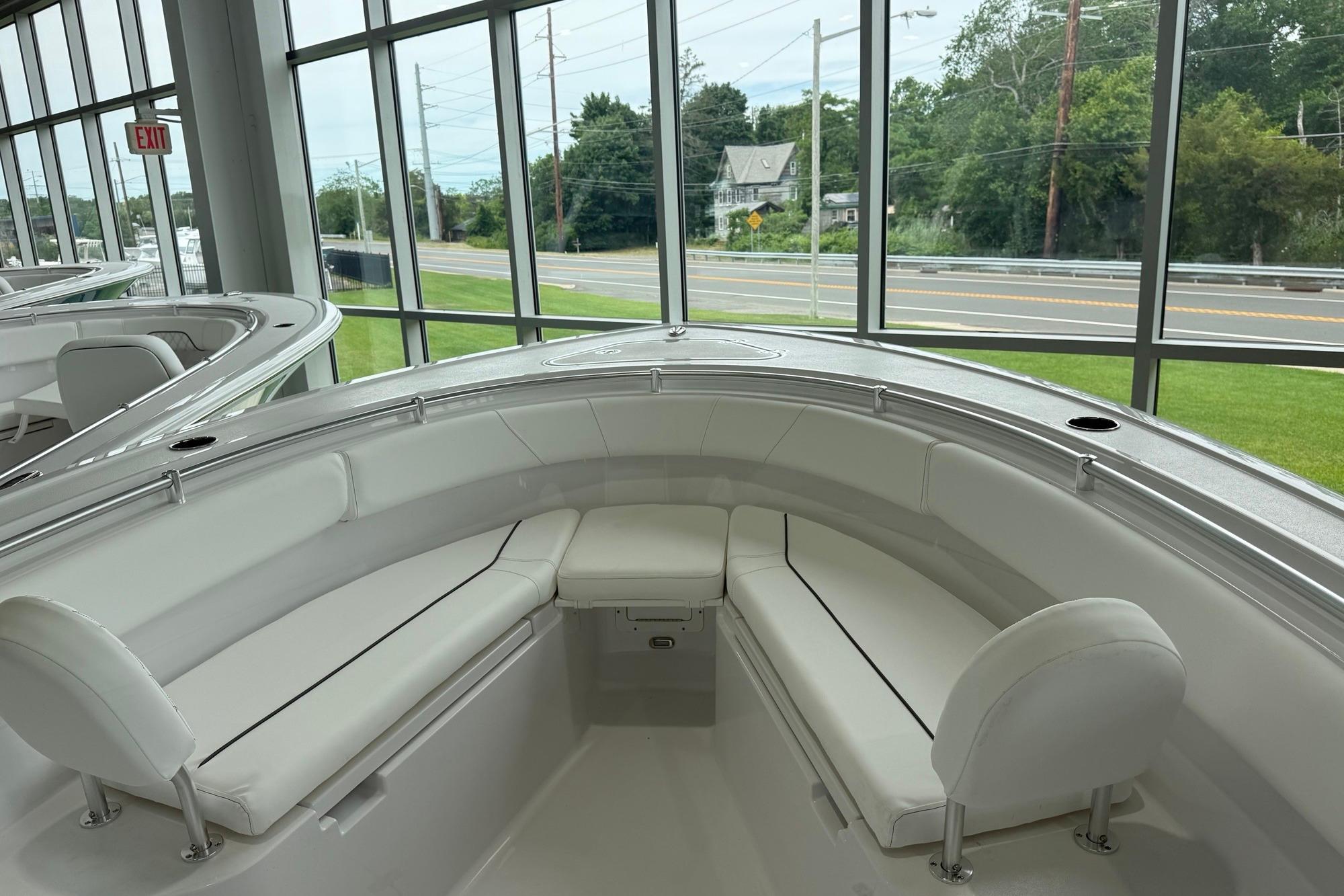 2026 Sportsman Open 252 Center Console boat interior with white seating in showroom.