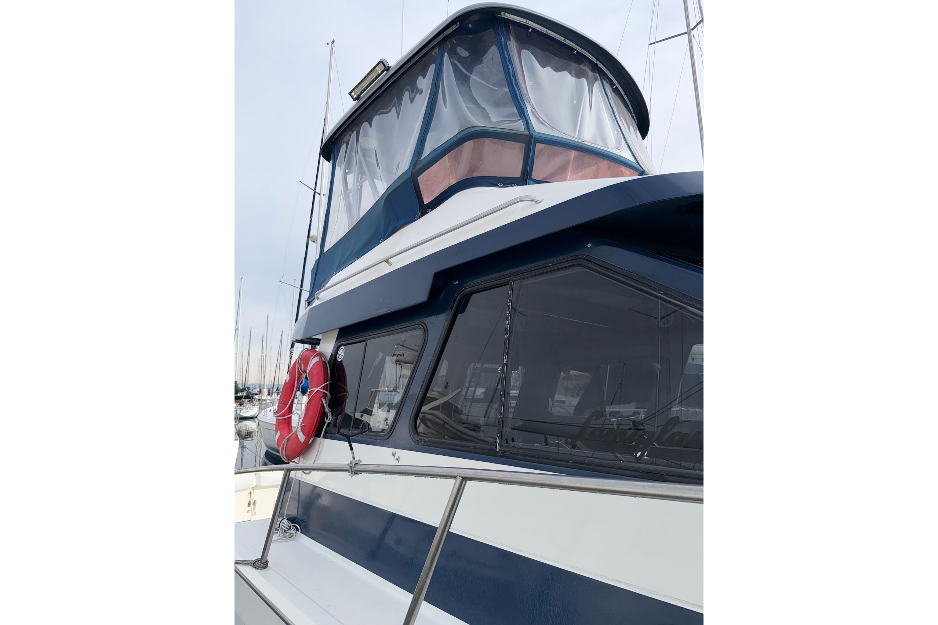 1990 Mediterranean Sport Fish boat with blue accents and a red life preserver.