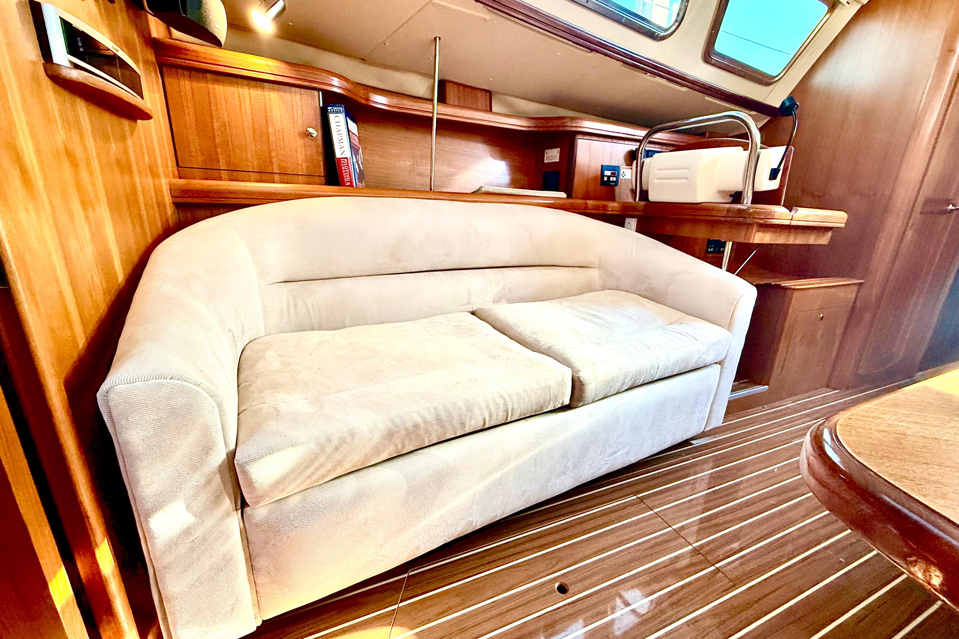 Luxurious interior of 2007 Hunter 41 Deck Salon with plush sofa and wooden accents.