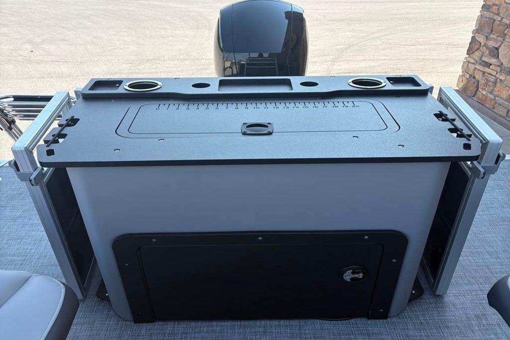 2026 Sun Tracker SportFish 22 DLX boat console with cup holders and storage compartment.