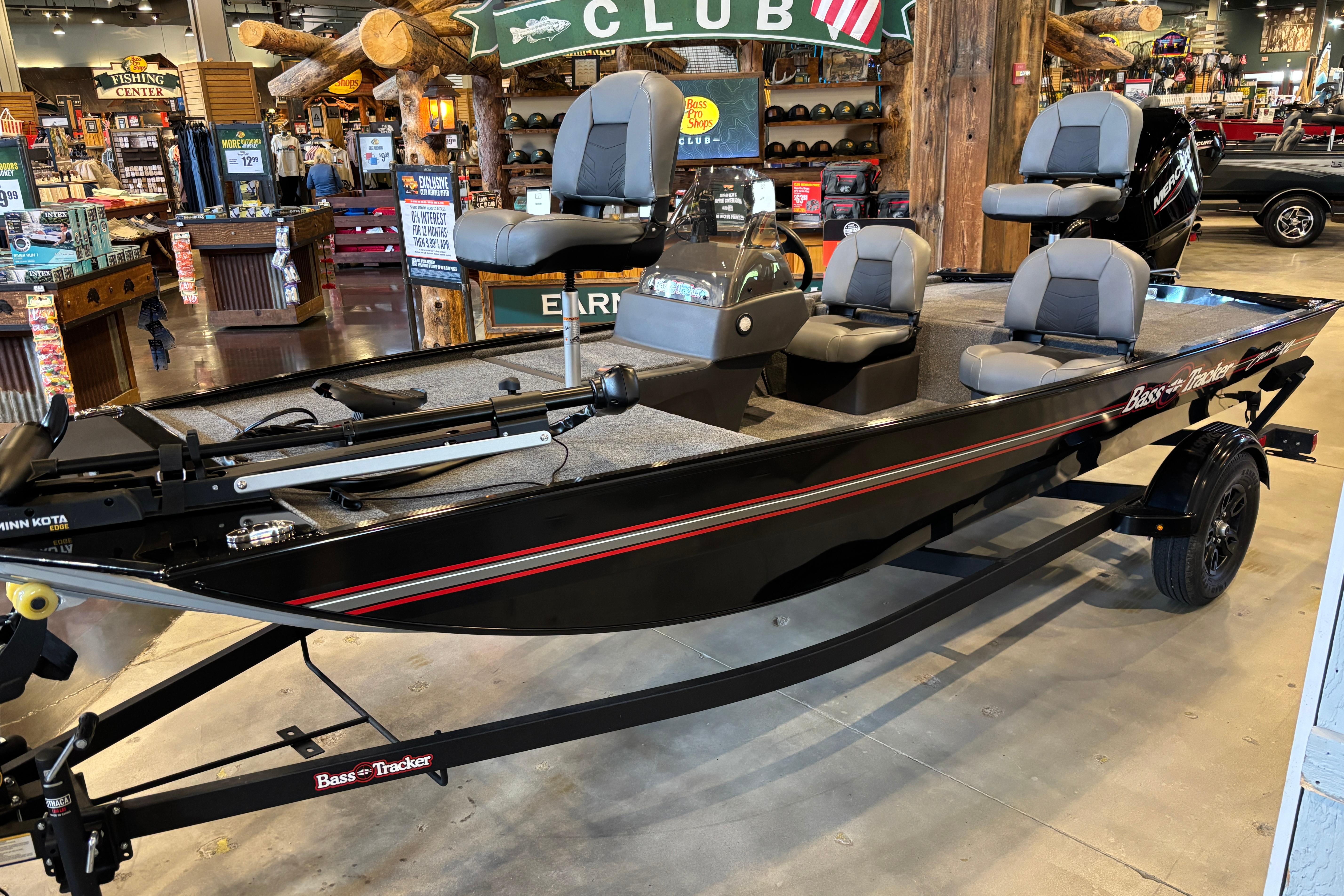 2026 Tracker Bass Tracker Classic XL boat displayed in a showroom with fishing gear.