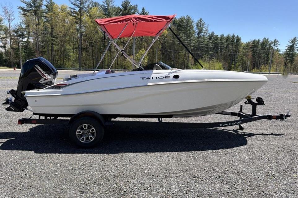 2026 Tahoe T18 boat with red canopy on trailer, parked outdoors.