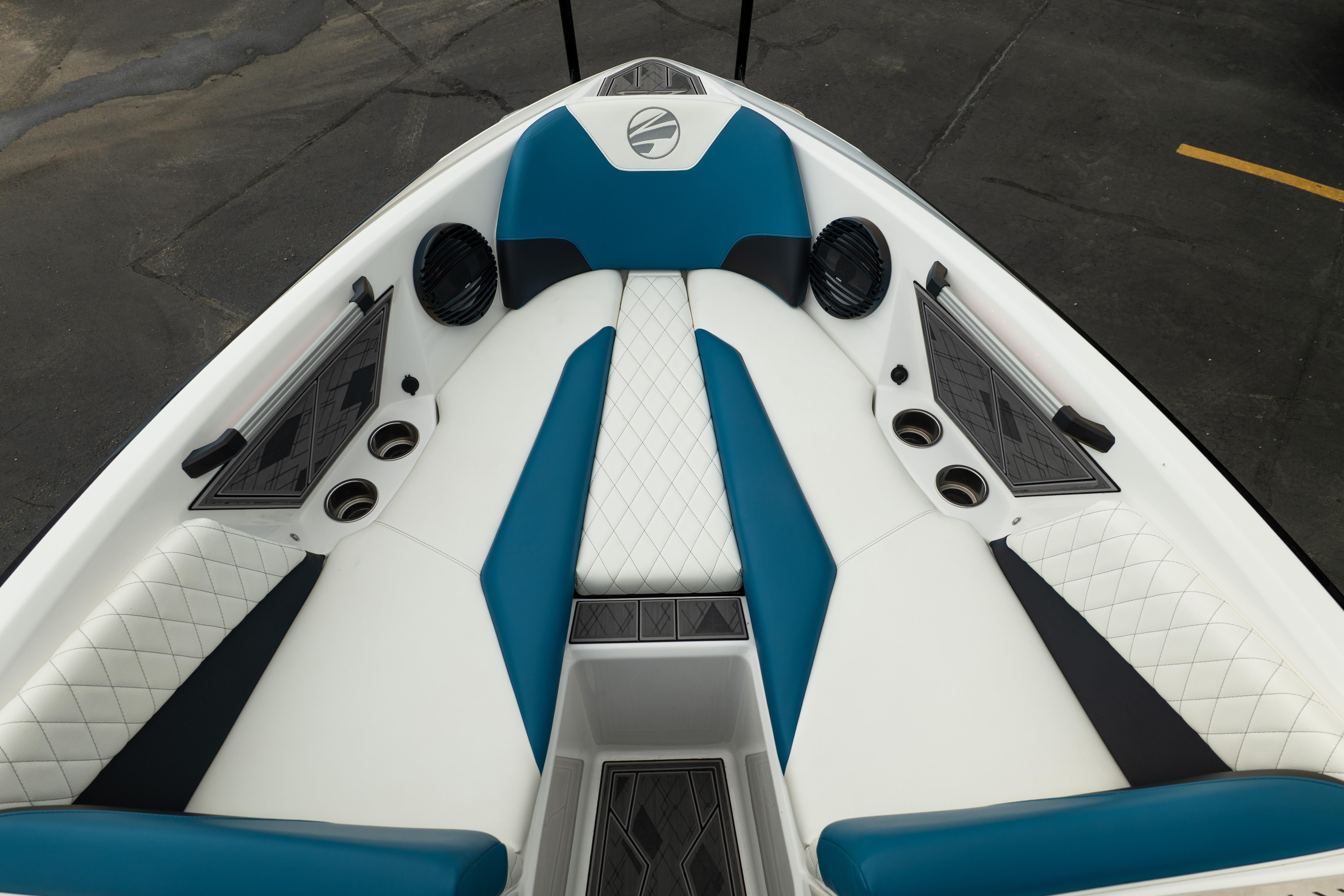 2024 Tigé Z5 boat interior with blue and white seating, cup holders, and speakers.