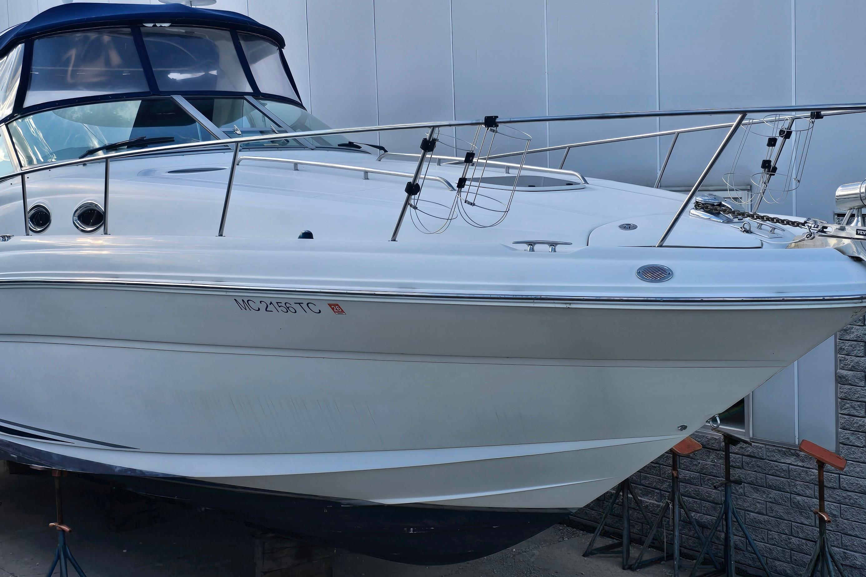 2007 Sea Ray 340 Sundancer boat docked, featuring sleek white hull and blue canopy.