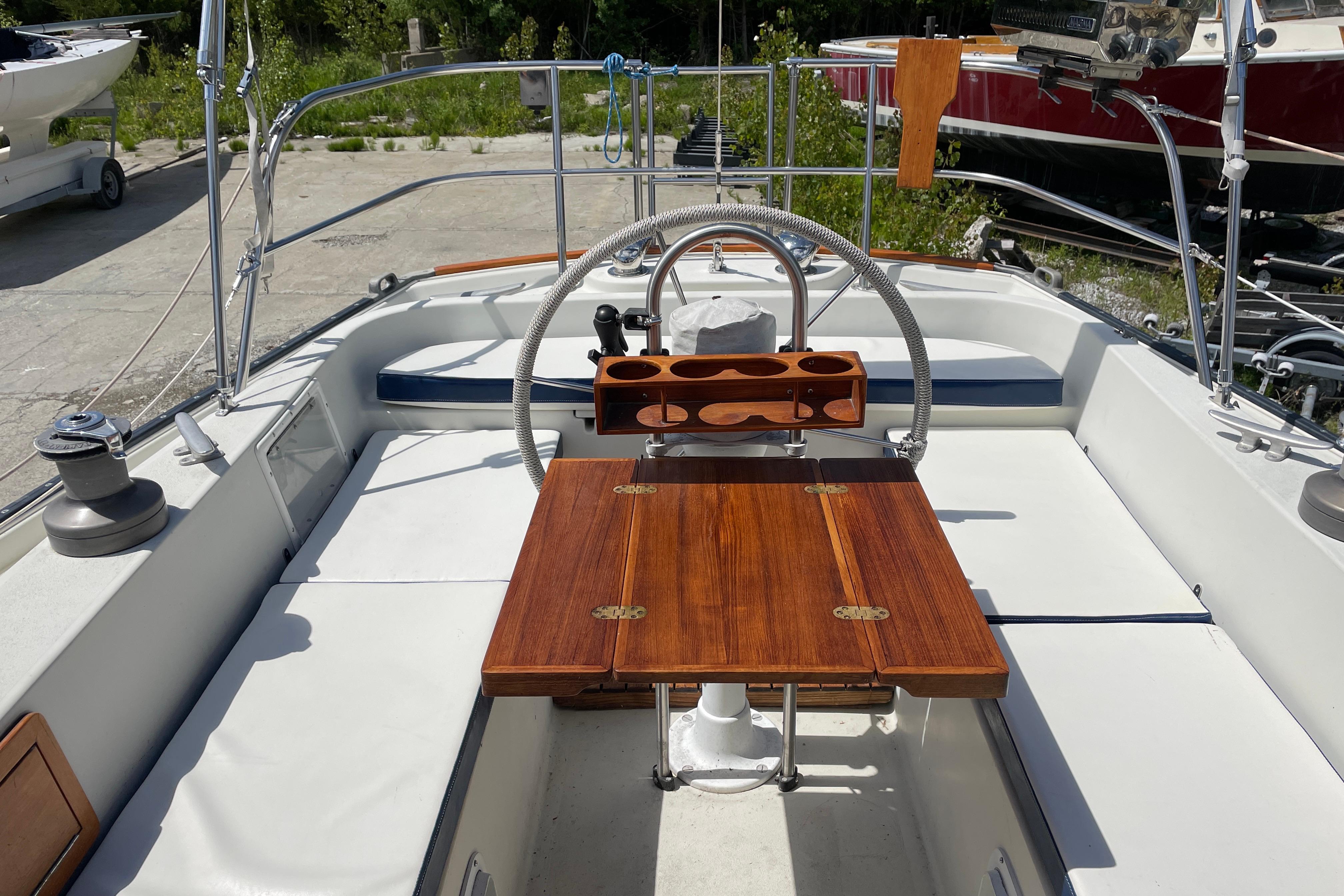 Cockpit of 1981 Hinterhoeller Niagara 35 sailboat with wooden table and steering wheel.