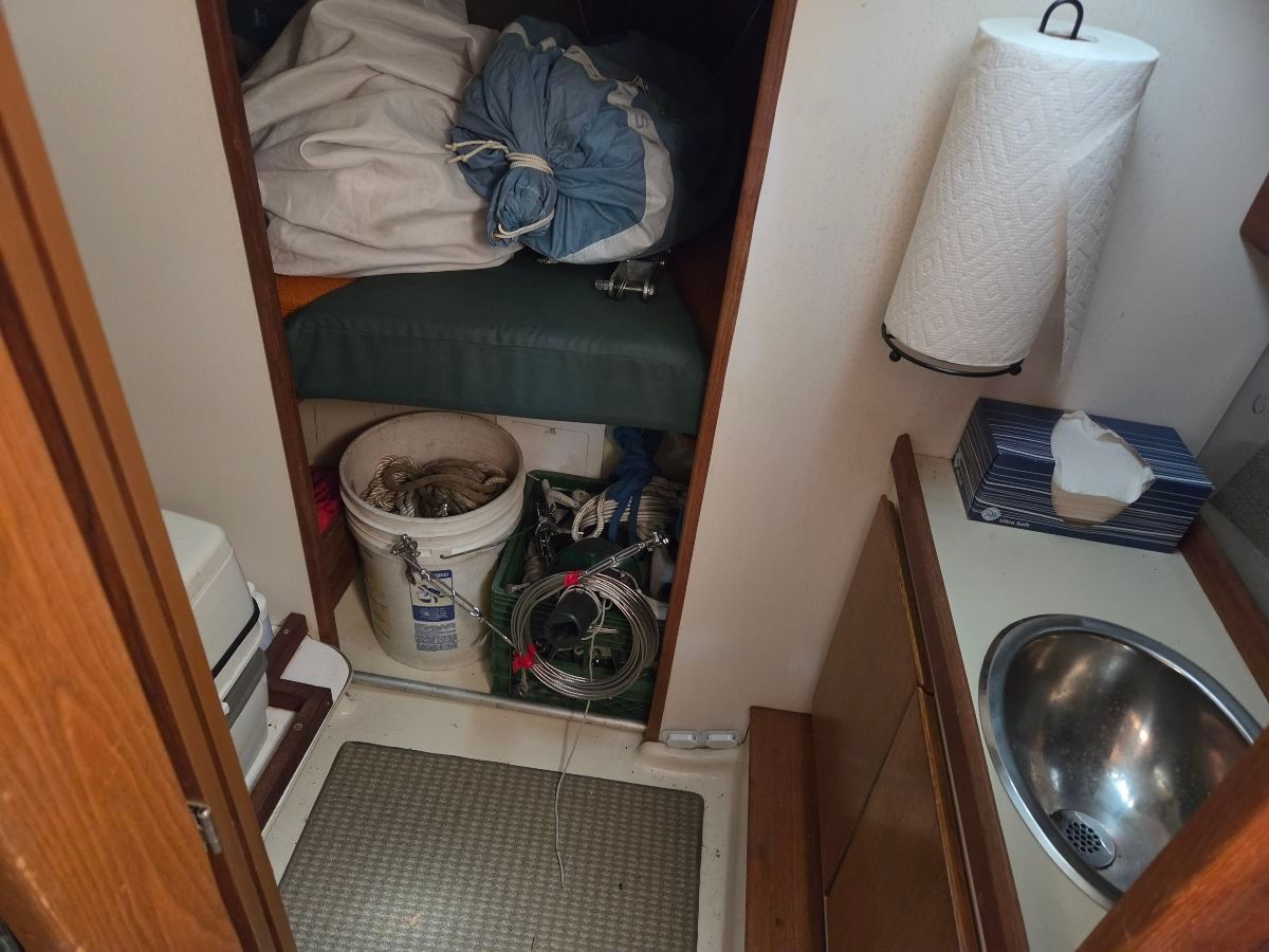Interior of a 1979 O'Day Sloop with bed, sink, and storage.