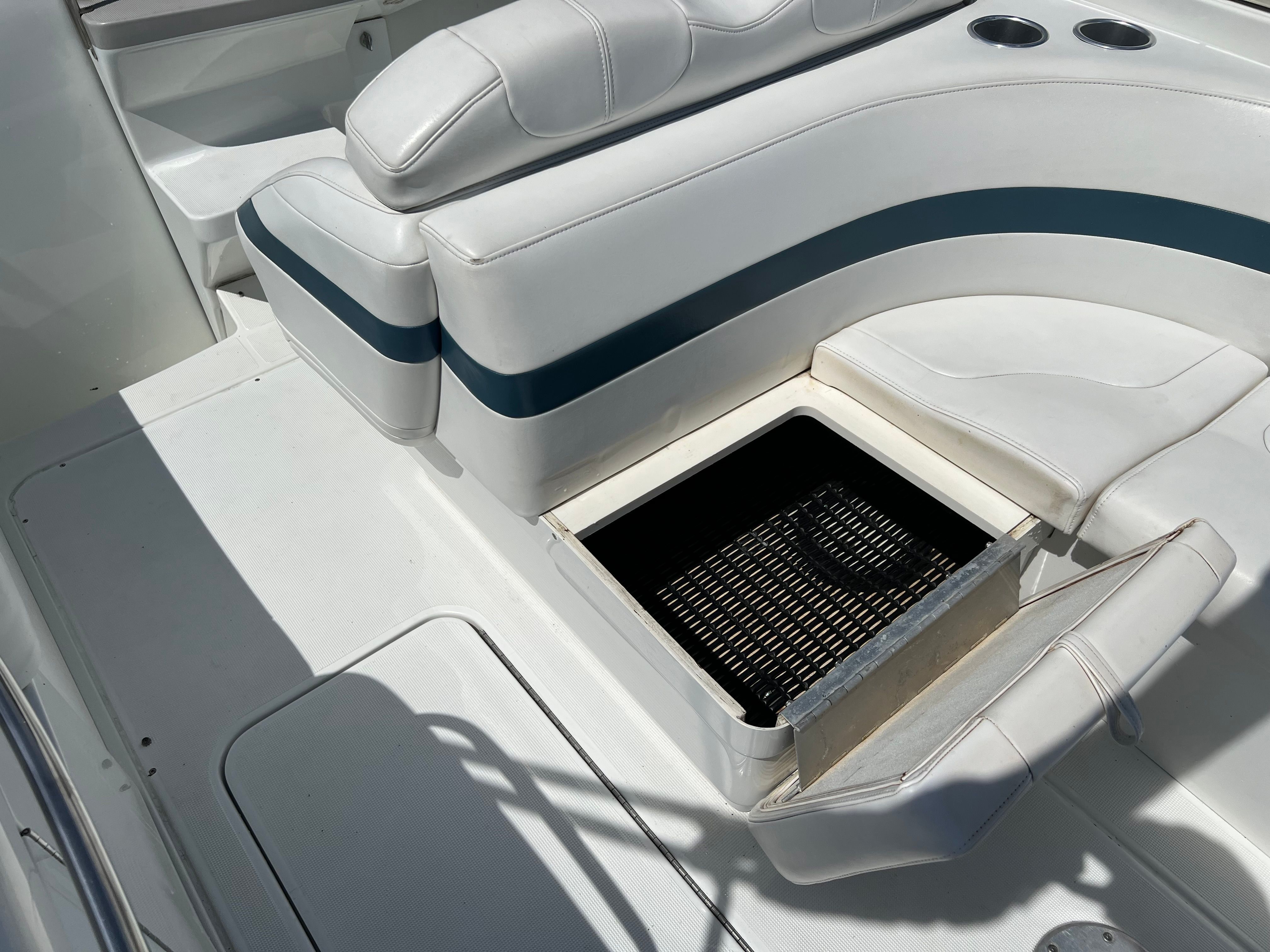 The image shows the cockpit of a 2005 Formula 260 Sun Sport with white cushioned seats and an open storage compartment.