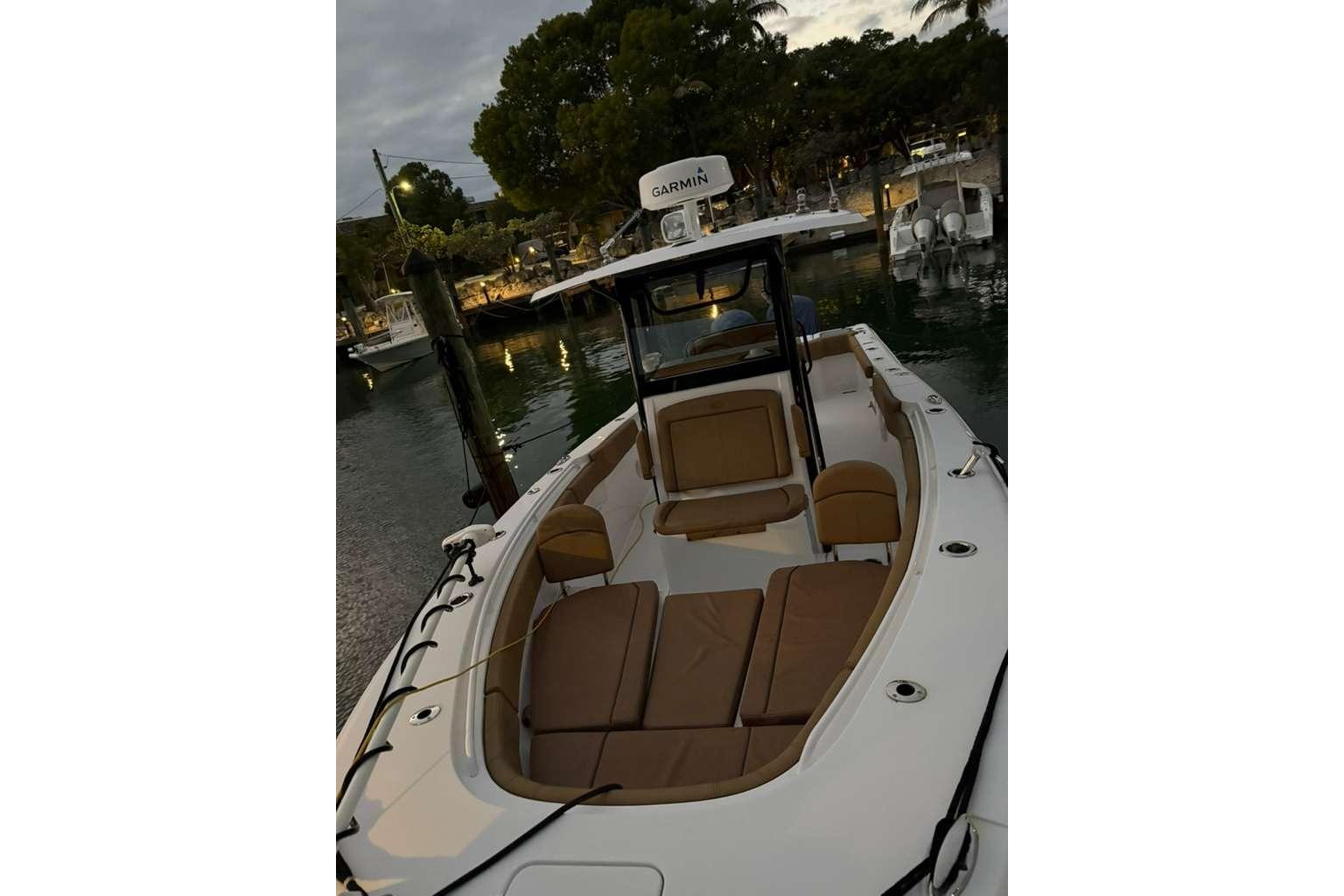 2021 Sea Hunt Gamefish 30 Forward Seating boat docked at marina during evening.