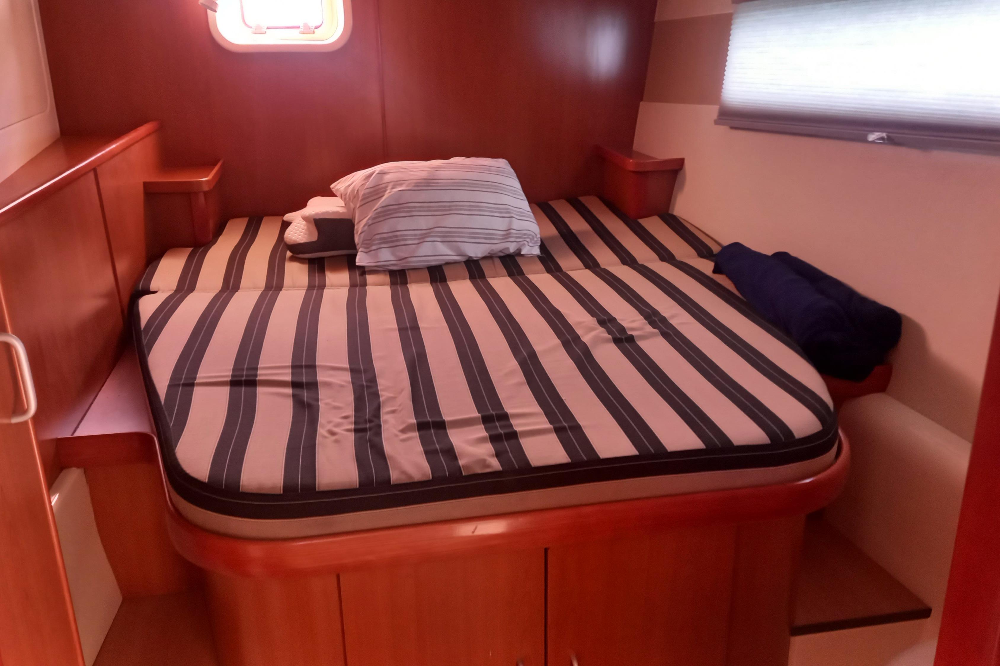 Cozy cabin interior of 2010 Leopard 46 yacht with striped bedding.