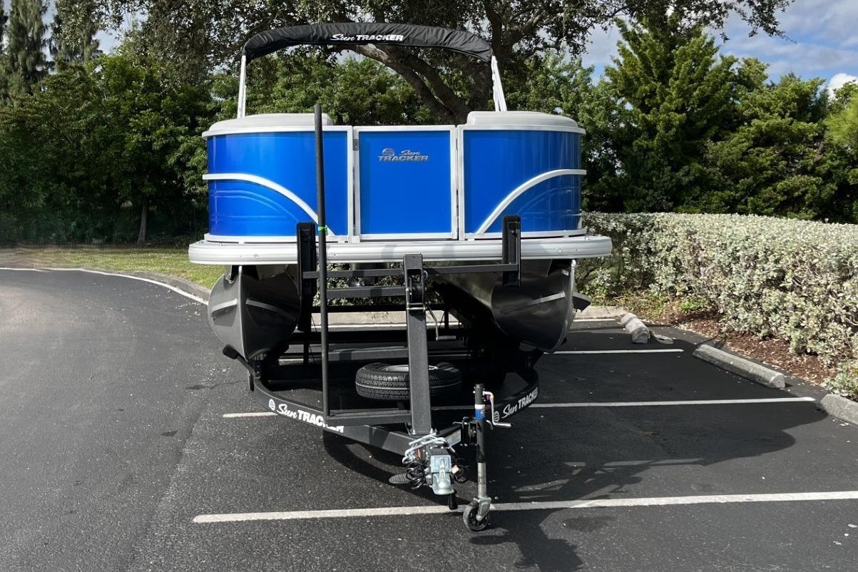 2026 Sun Tracker Party Barge 20 DLX on trailer in parking lot.