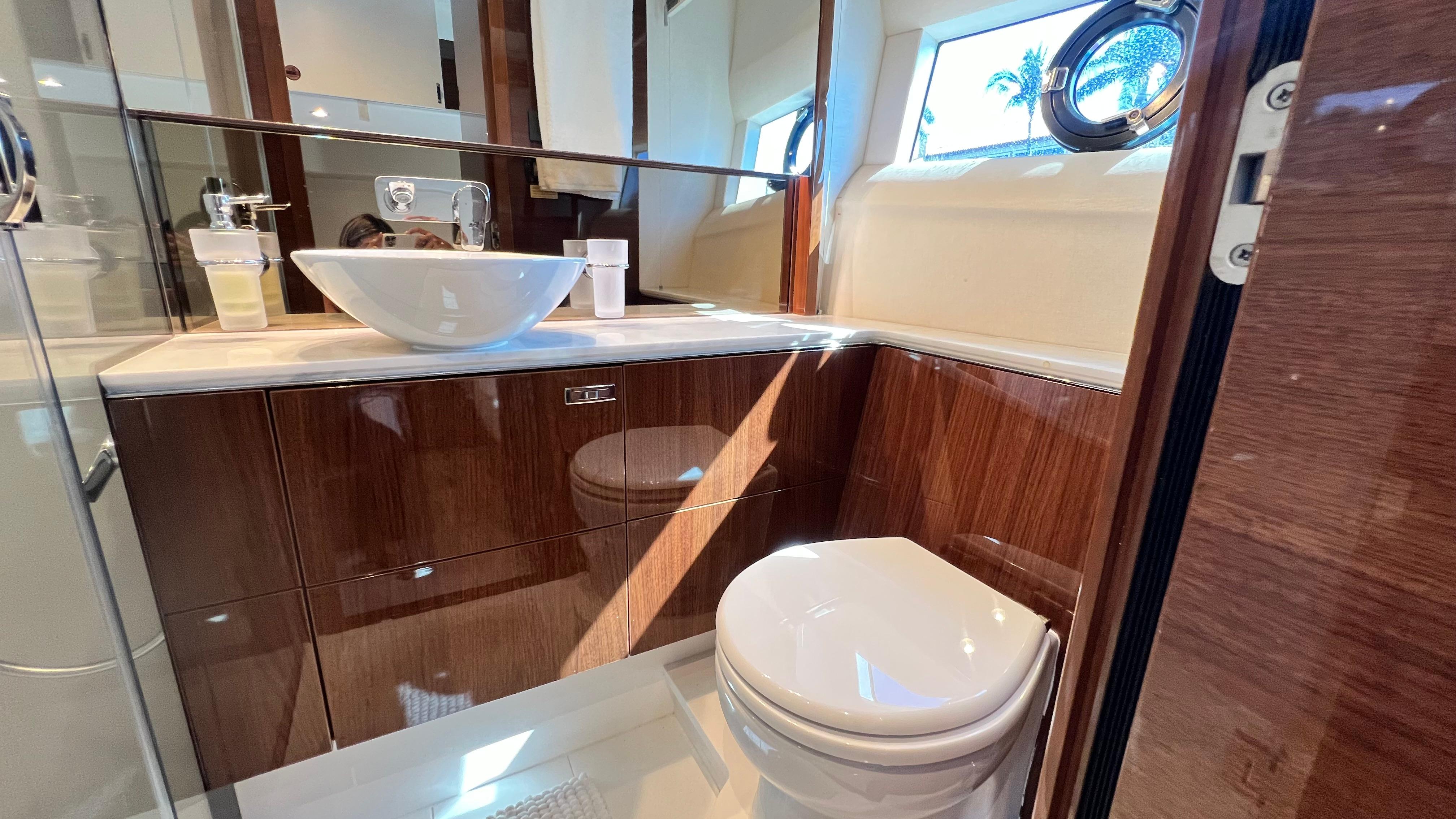 Luxurious bathroom in 2019 Princess F62 yacht with modern fixtures and wooden cabinetry.