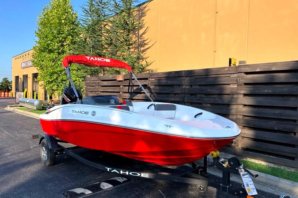 2026 Tahoe T16 boat with red and white design on a trailer, parked outdoors.