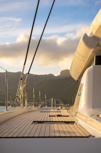 2025 Lagoon 60 yacht deck with scenic mountain backdrop at sunset.