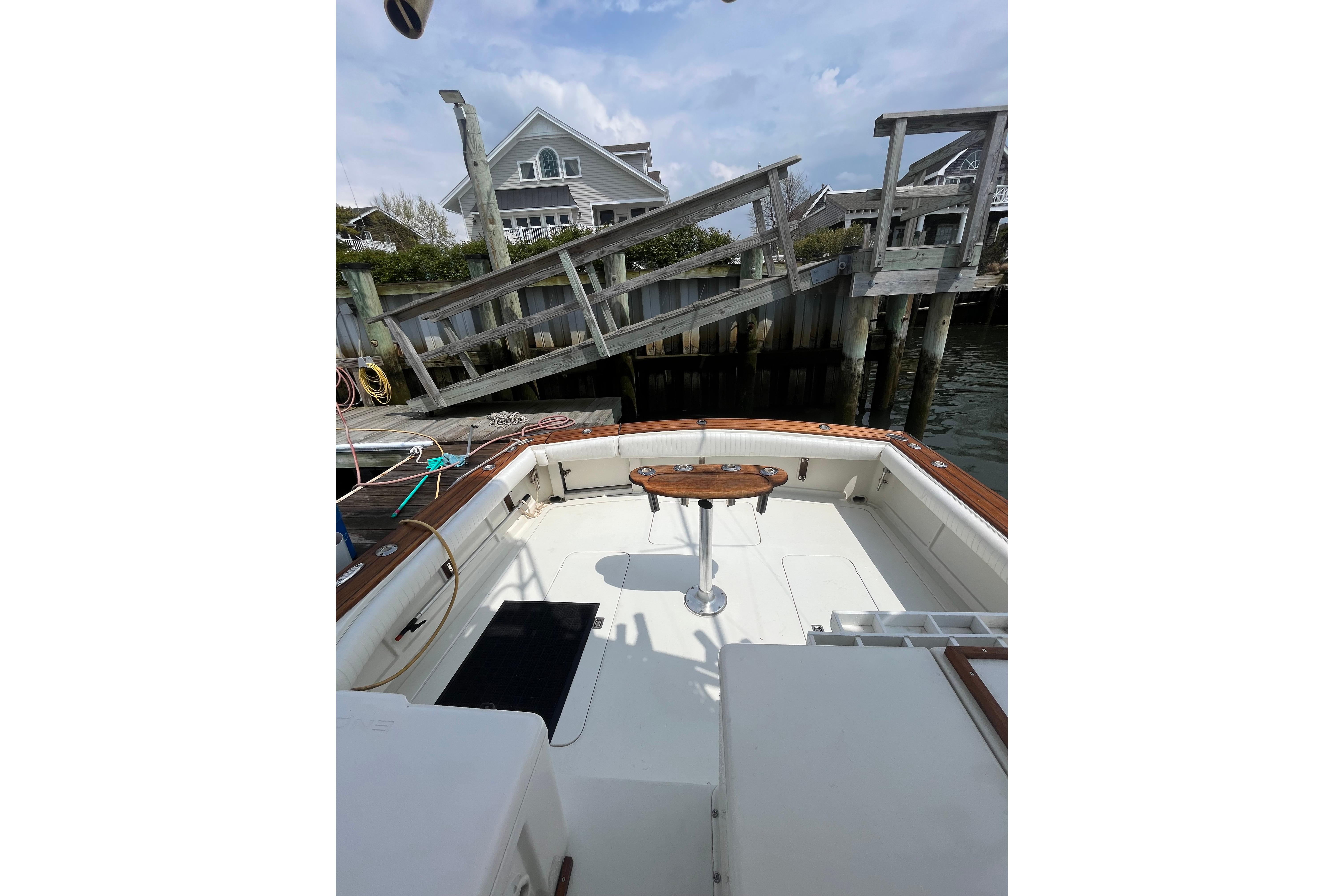 1989 Blackfin 31 Combi boat docked, featuring spacious deck and wooden accents.