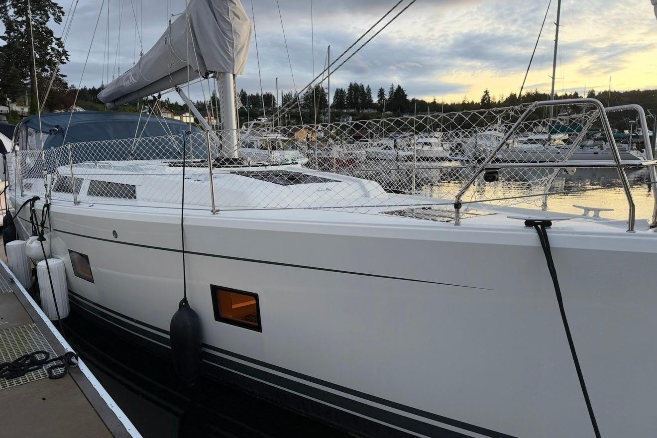 2022 Hanse 418 sailboat docked at marina during sunset, showcasing sleek design and modern features.