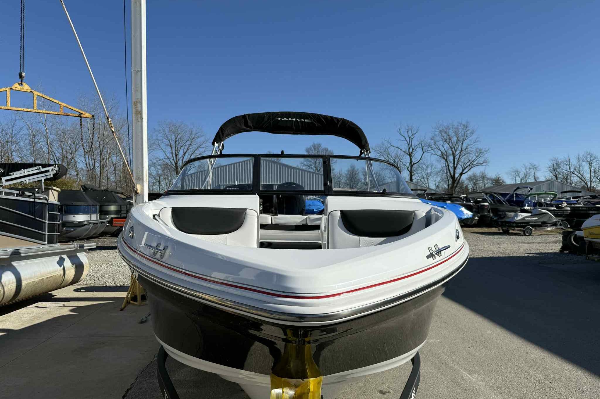 2021 Tahoe 550 TS boat in a marina, clear sky, surrounded by other boats.